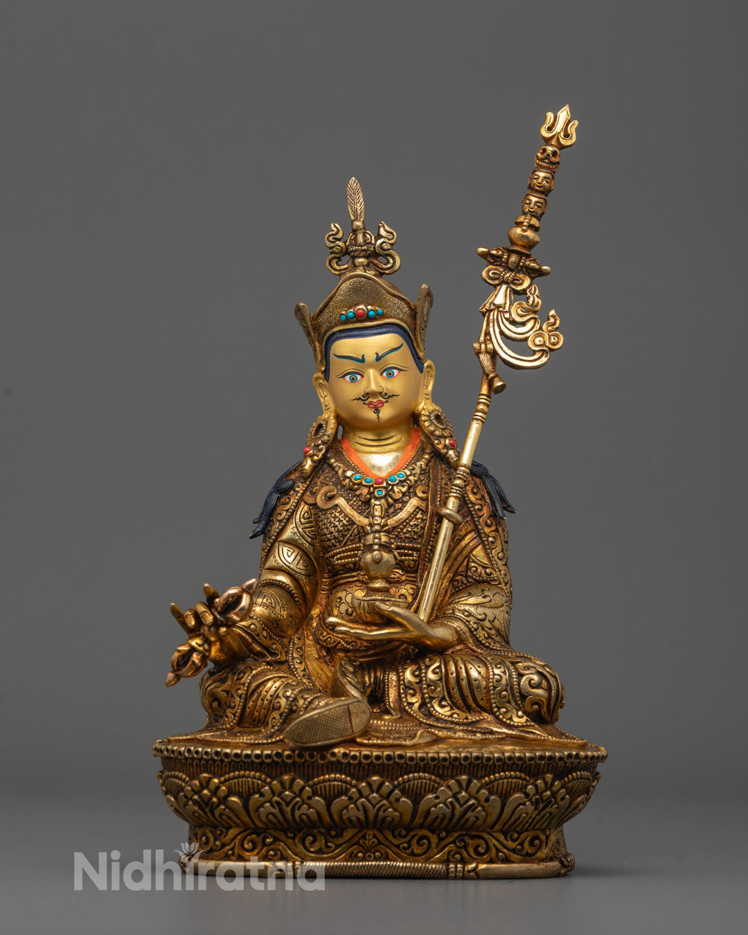 Front view of Guru Rinpoche statue with gold-gilded face and detailed lotus base
