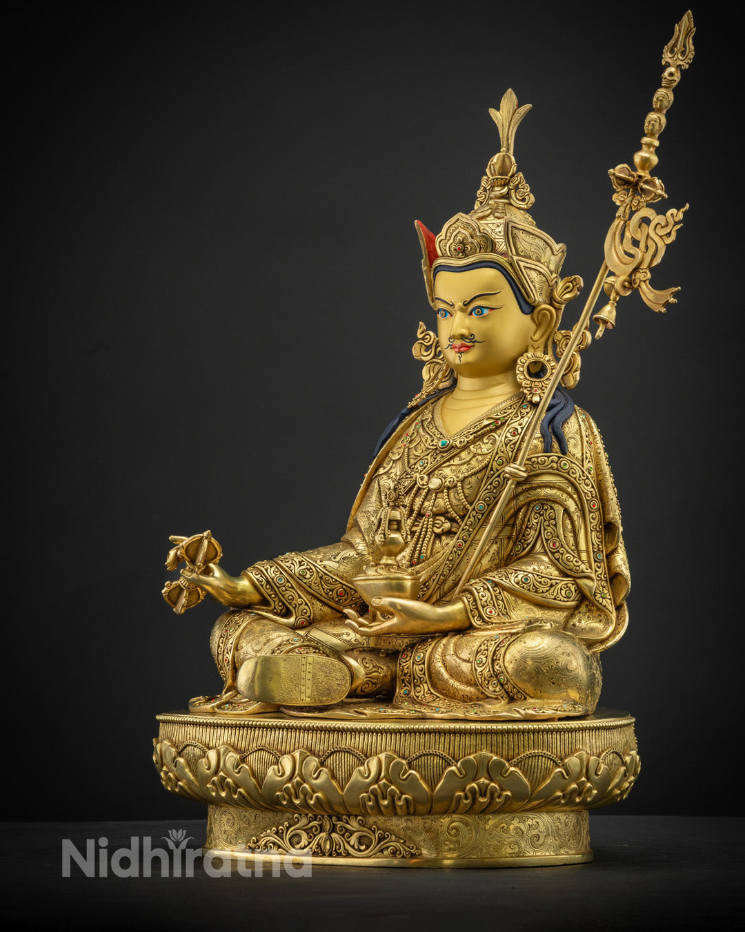 holding a vajra in his right hand and a skull cup in his left