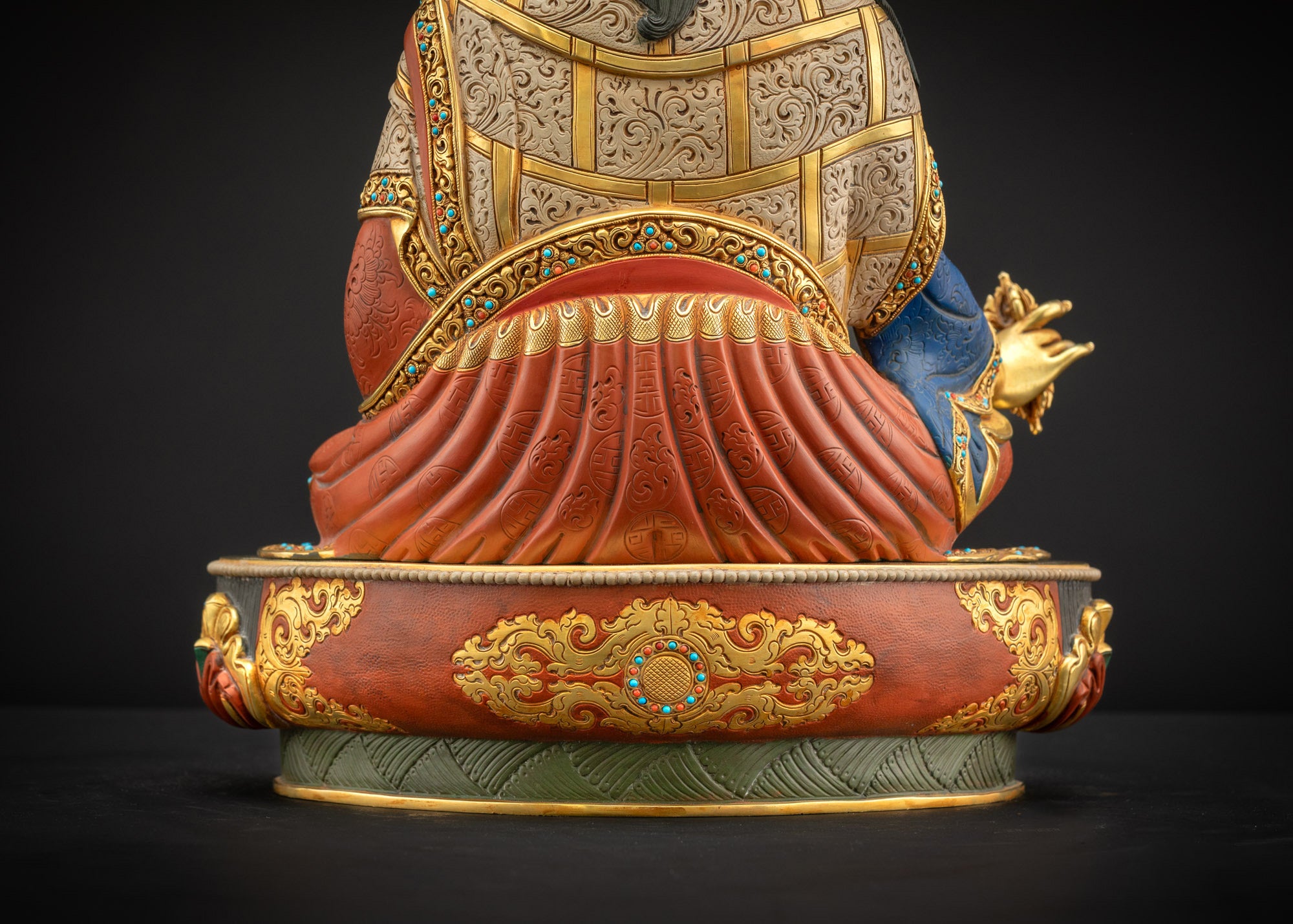 Lower landscape back view of Guru Rinpoche statue showing lotus base and detailed robe folds.