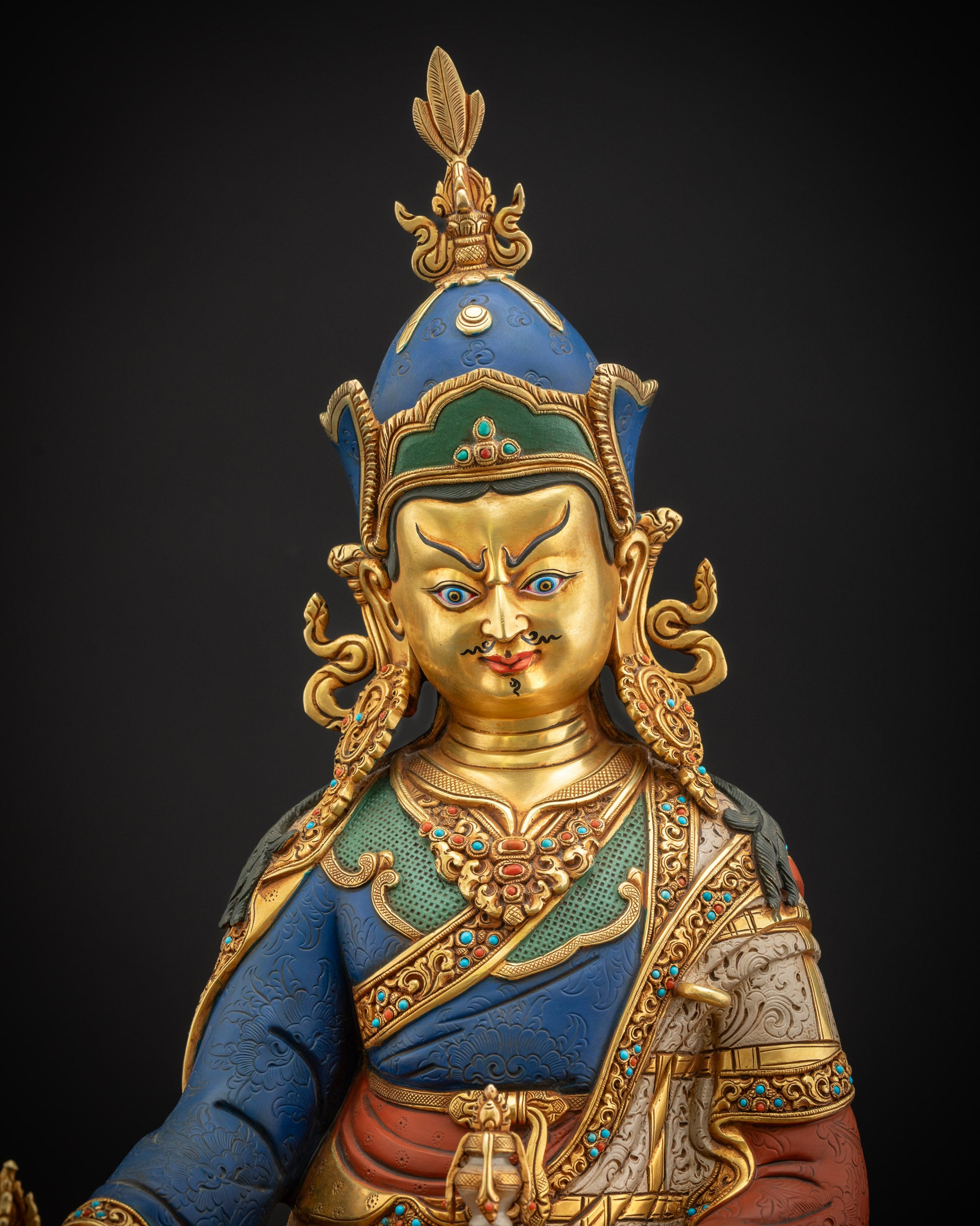 Close-up of Guru Rinpoche statue showing overall copper craftsmanship and gold-accented details.