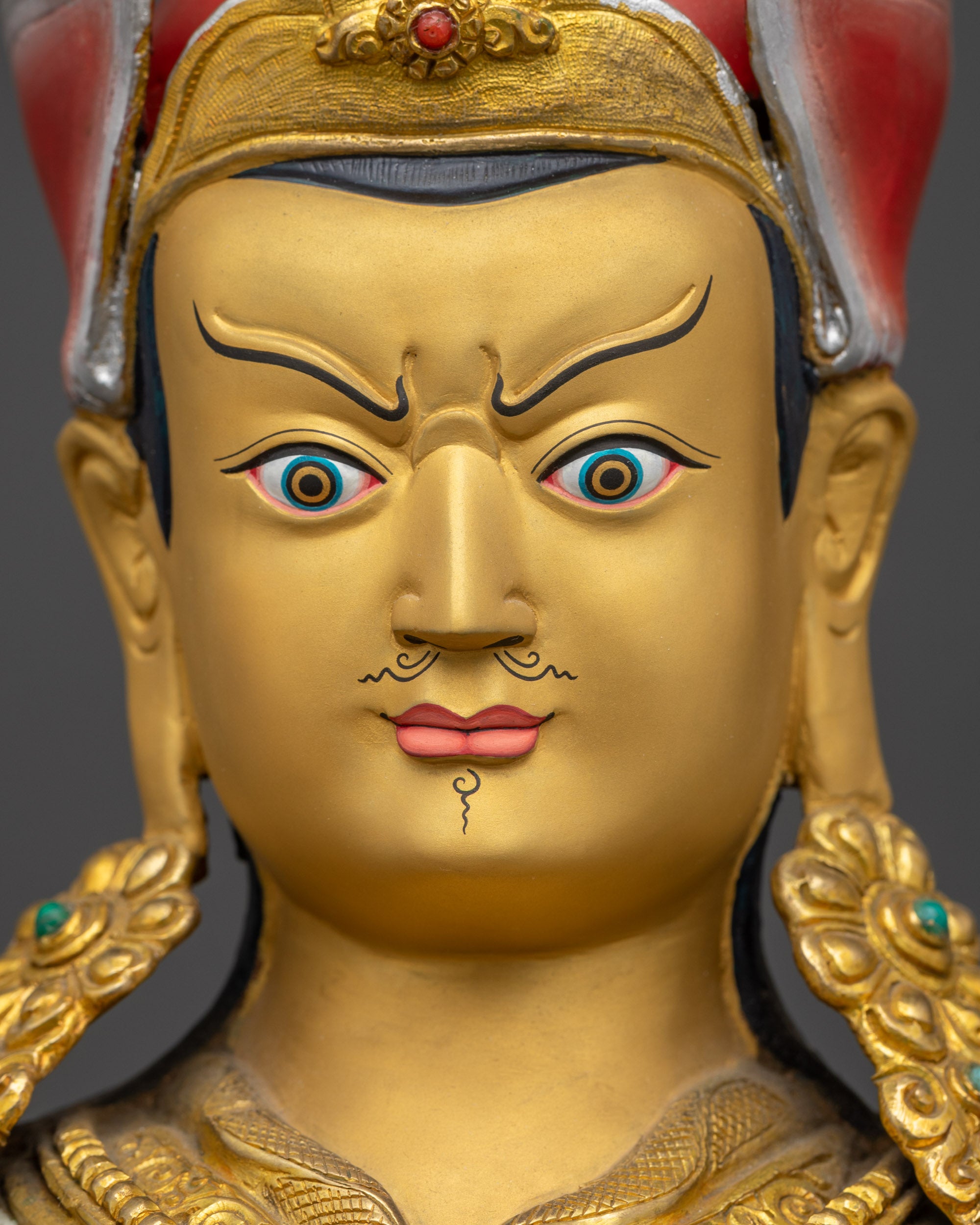Guru Rinpoche Statue detailed close up face with semi-wrathful gold-gilded facial expression
