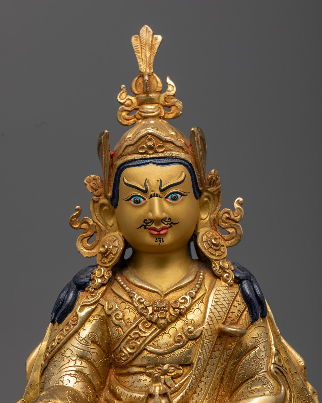 Guru Rinpoche's golden face and hands holding tantric vajra and kapala (skull cup)