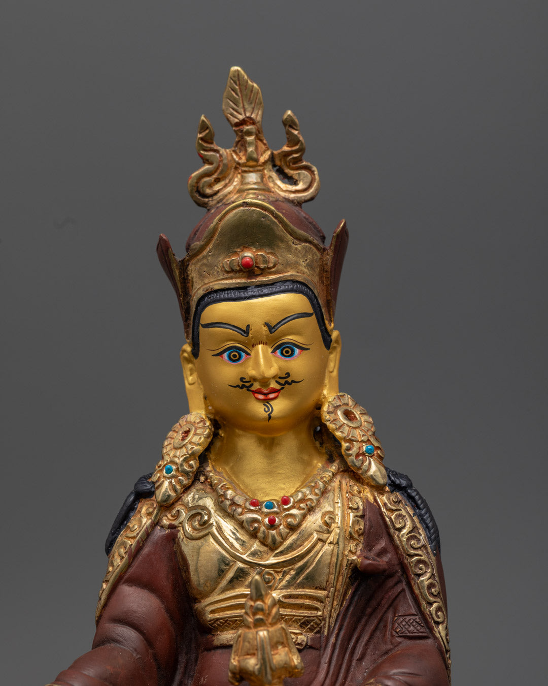 Guru Rinpoche statue holding vajra and kapala, adorned with semi-precious stones and rich acrylic painting – sacred Tibetan Buddhist icon