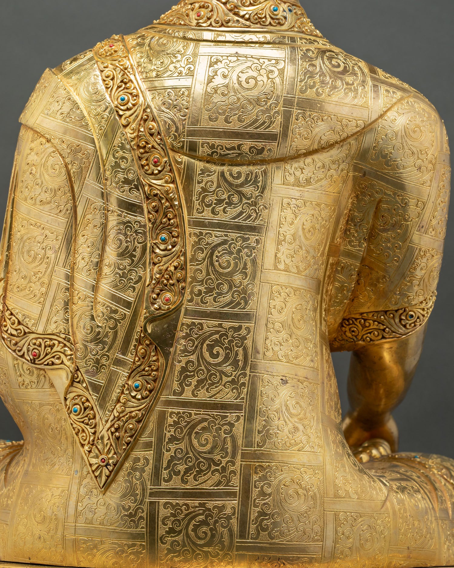 Hand-engraved floral robe pattern on back of gold gilded Nepalese Buddha statue