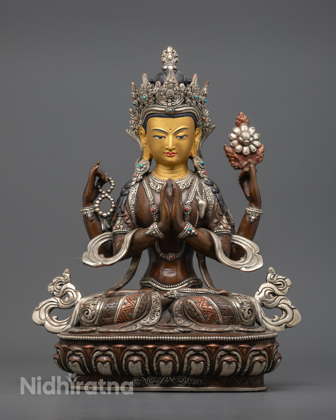 Handcrafted Chenrezig statue of compassion in meditation pose, featuring 24K gold face on oxidized copper body with silver detailing - sacred Buddhist art from Nepal