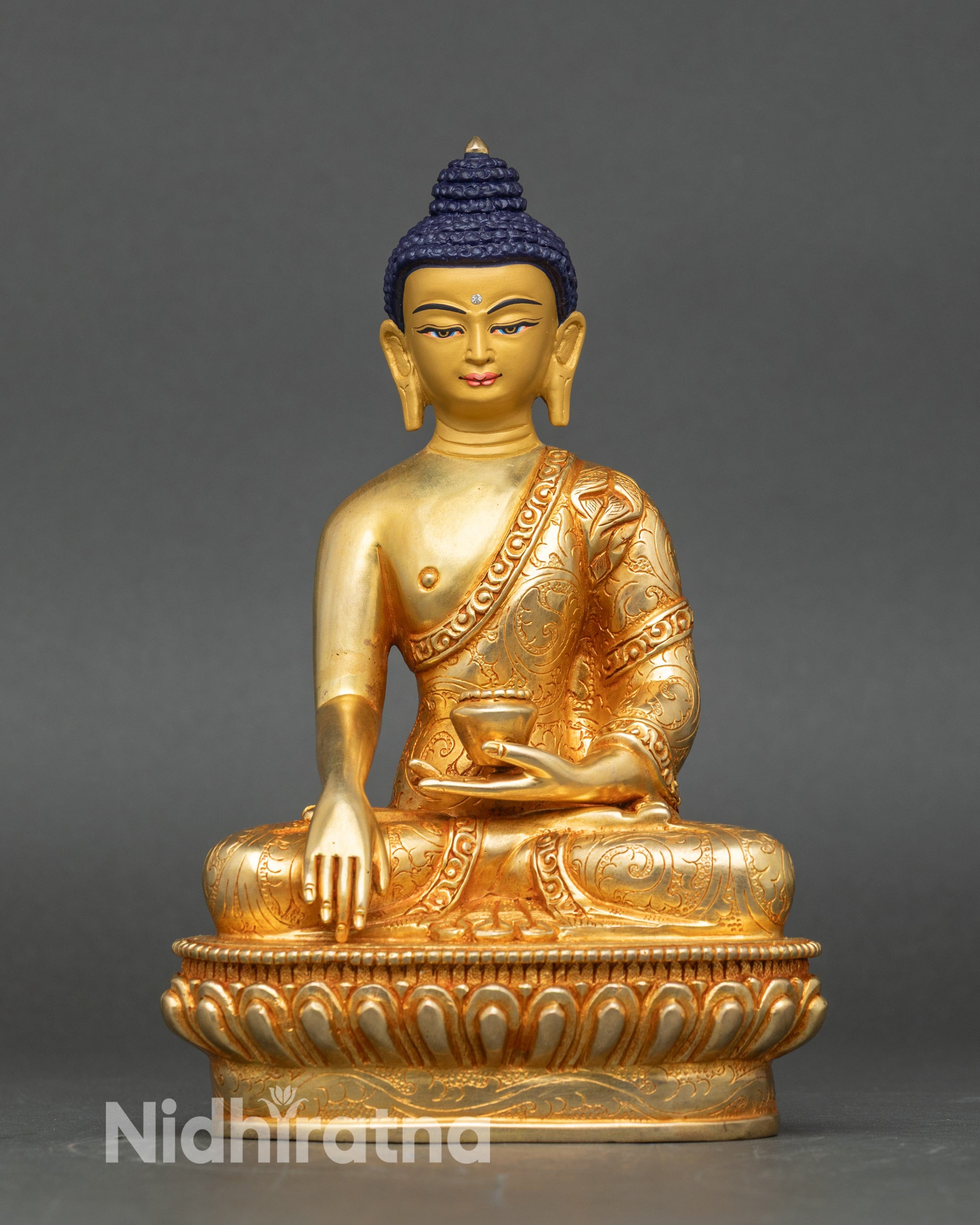 Handcrafted Nepalese Buddha statue in lotus pose with gold gilding and monkβs bowl