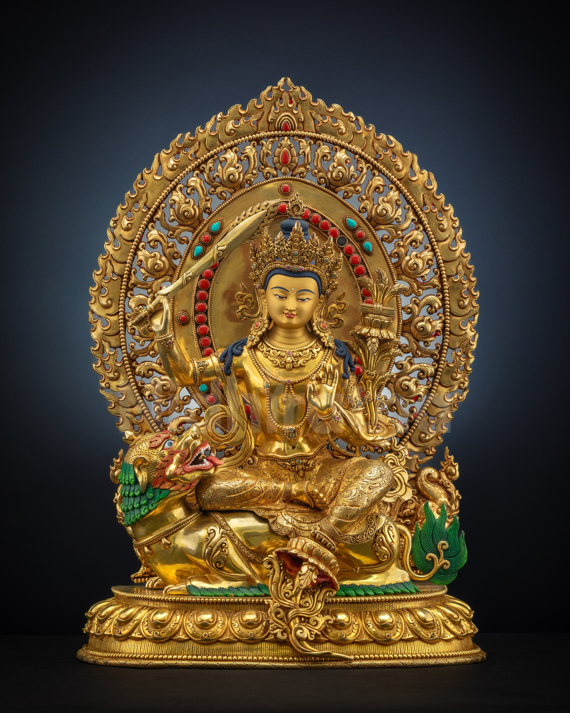 Head-on view of lion-seated Simhada Manjushri statue with gold fire-gilding and radiant halo