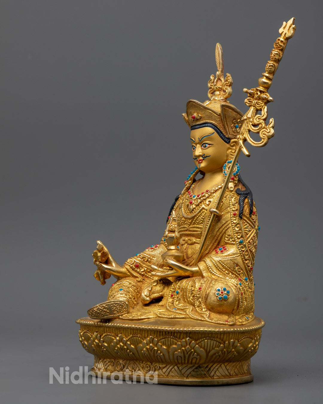 Intricate carvings on chögu, shamtab, and zen garments of the Guru Rinpoche Statue with ornate Buddhist jewelry and semi-precious stone inlays.