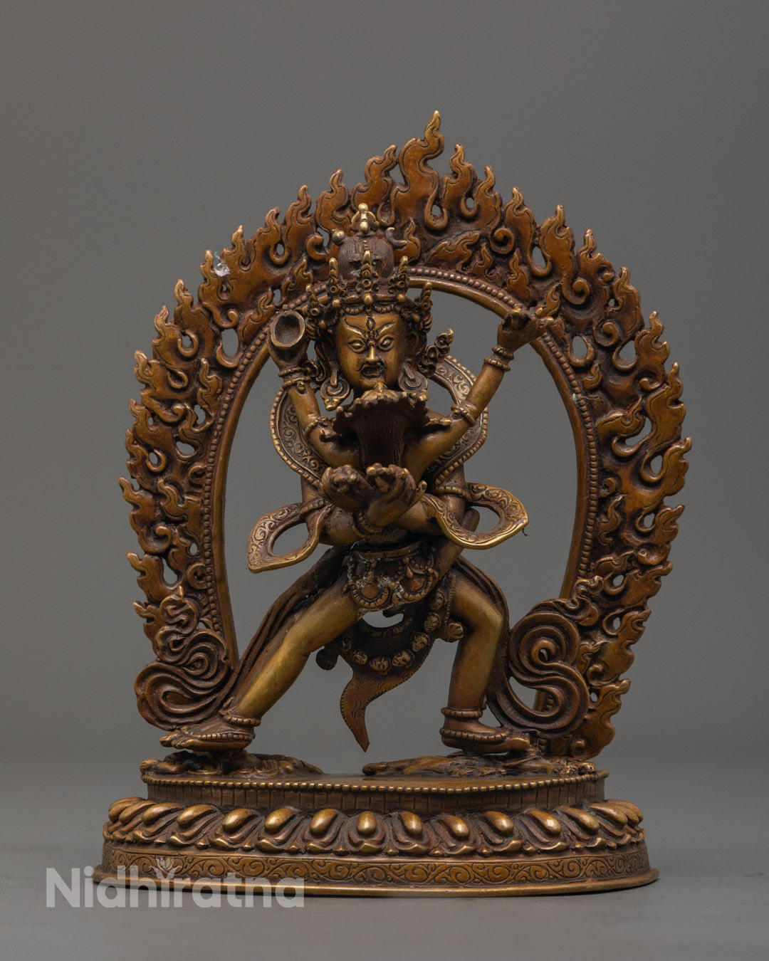 Intricately detailed Chakrasamvara statue standing on a sun disc with fiery aura, crafted from oxidized copper.