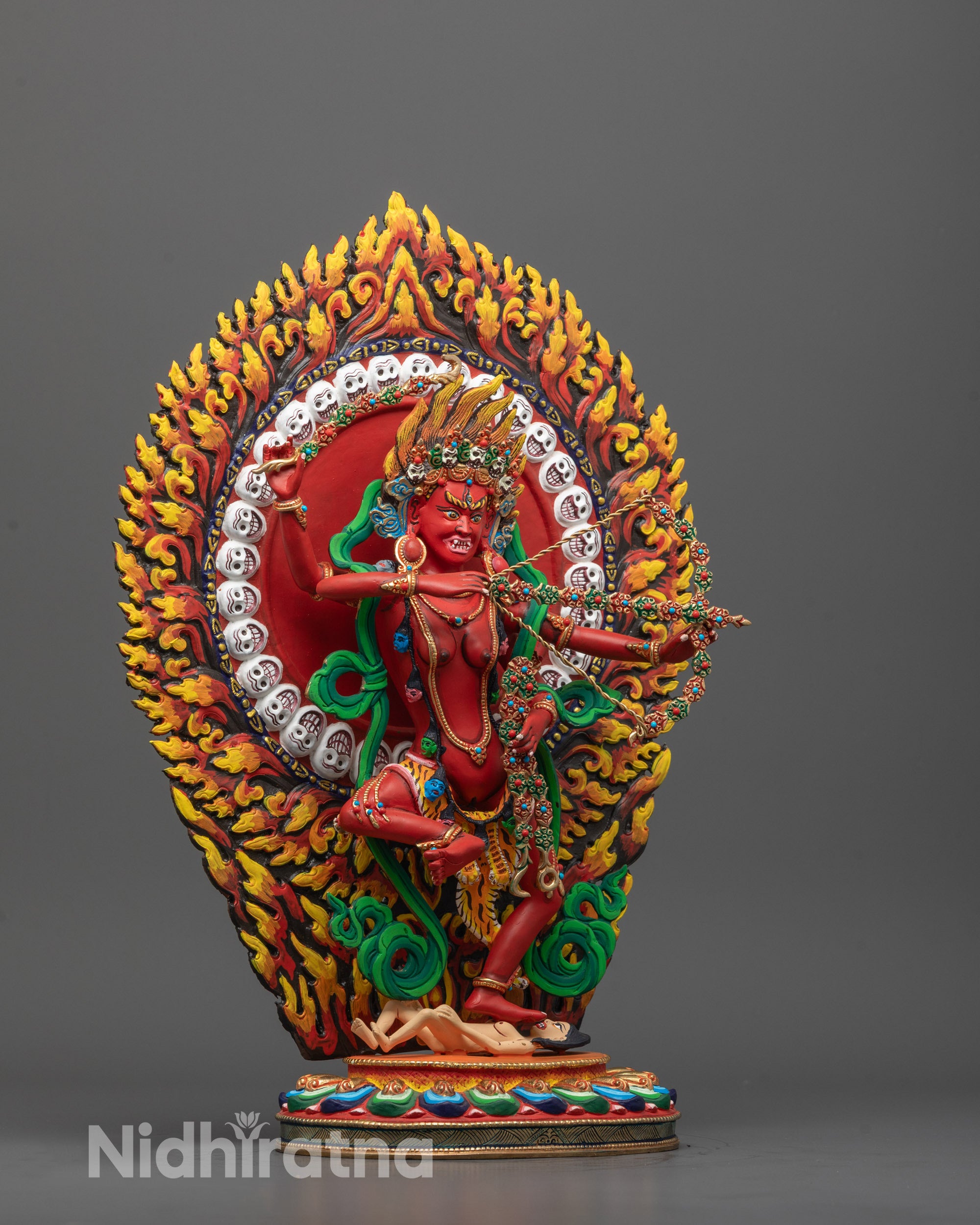 Side view of Fierce Kurukulla deity statue with acrylic red finish and detailed lotus pedestal