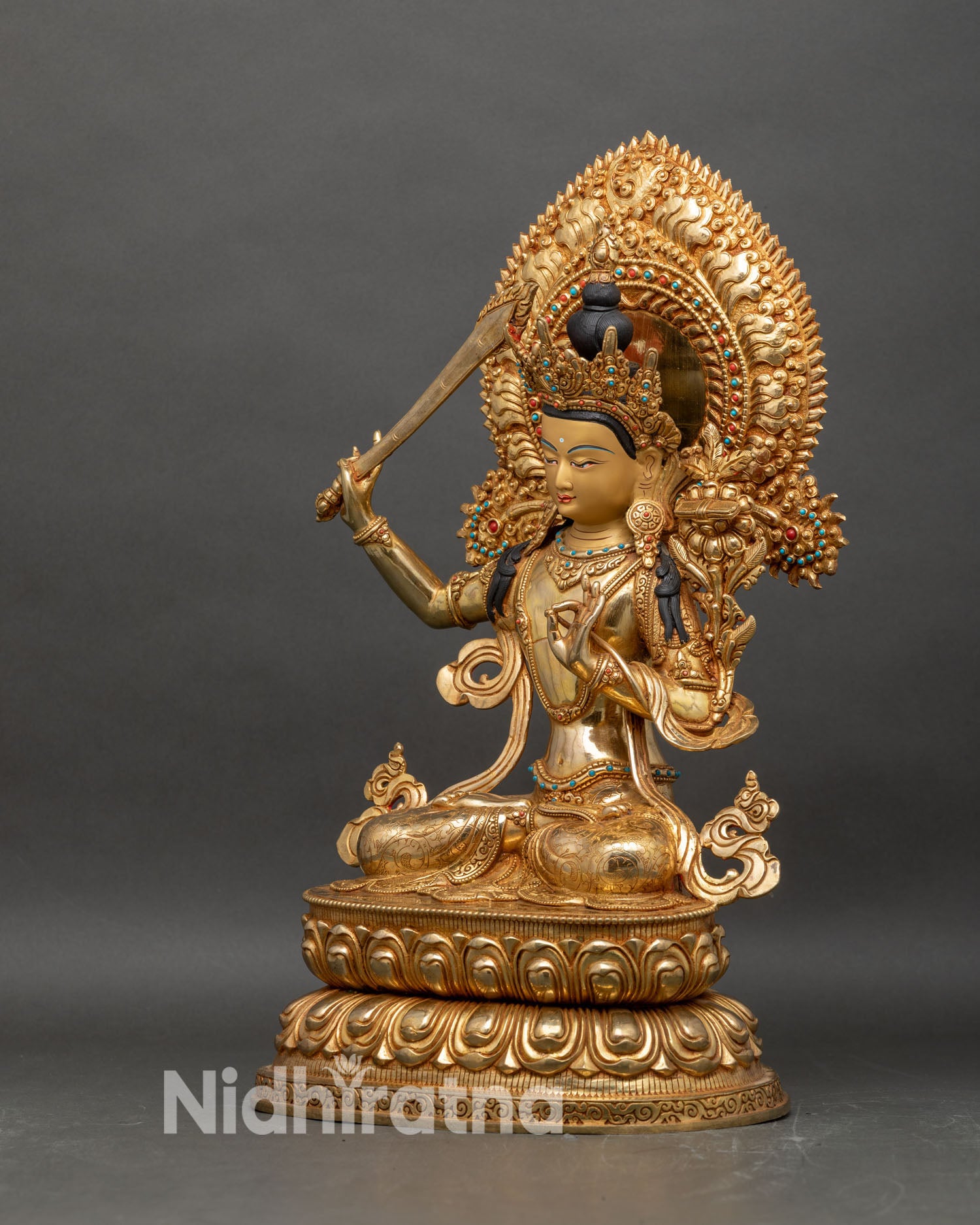 Left profile of Manjushri Bodhisattva statue with ornate halo and double lotus base