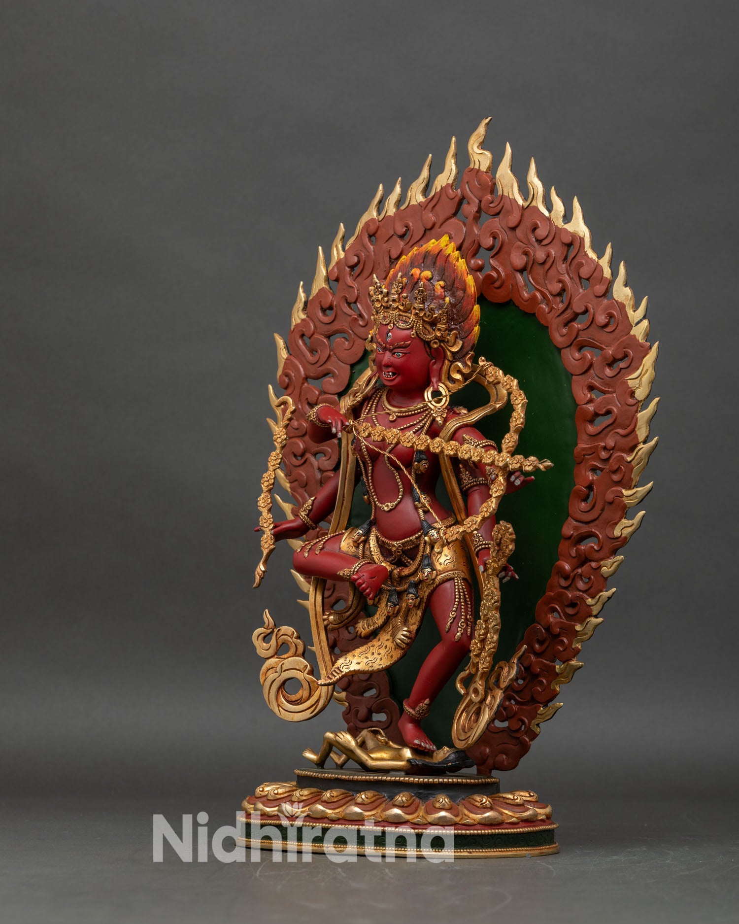 Left-side view of Kurukulla statue, copper and gold, seated on lotus pedestal