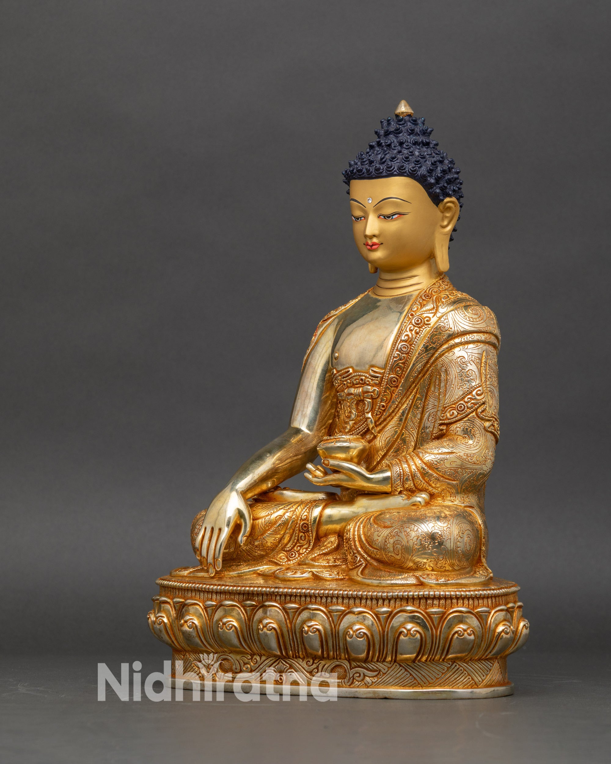 Left-side view of Shakyamuni Buddha sculpture showing lotus throne and detailed robe