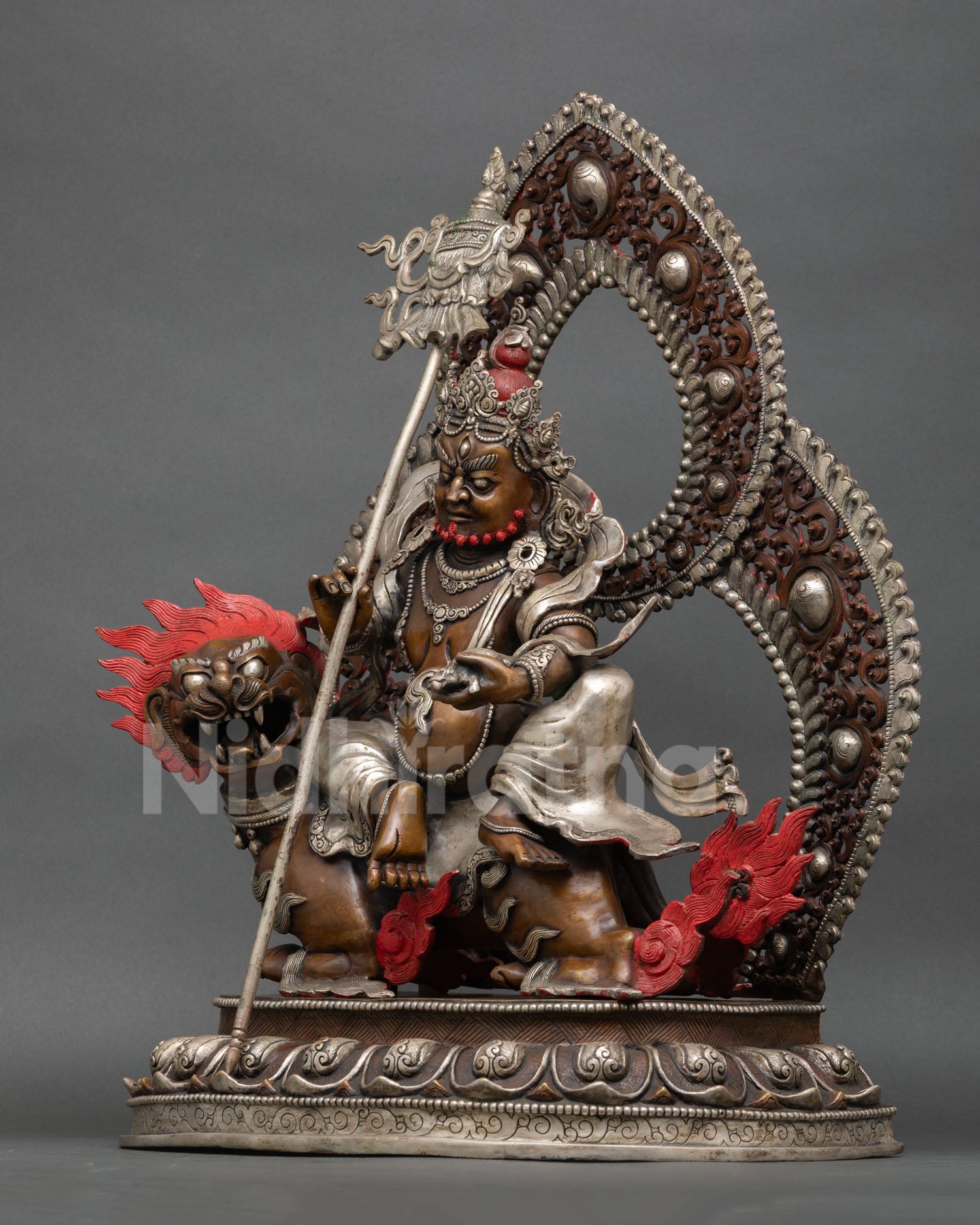 Left side view of Vaishravana statue highlighting lotus base, halo craftsmanship, and silver ornaments