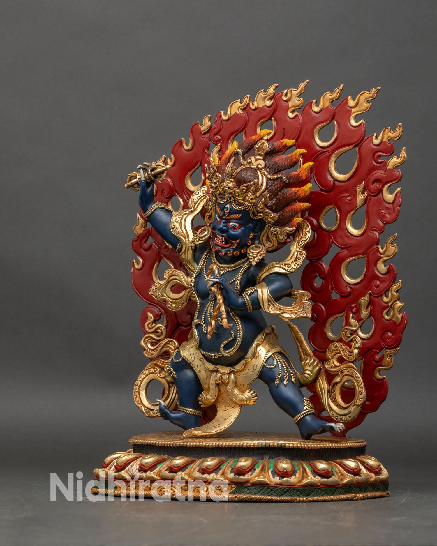 Left-side view of Vajrapani statue, ornate lotus pedestal and dramatic flame details