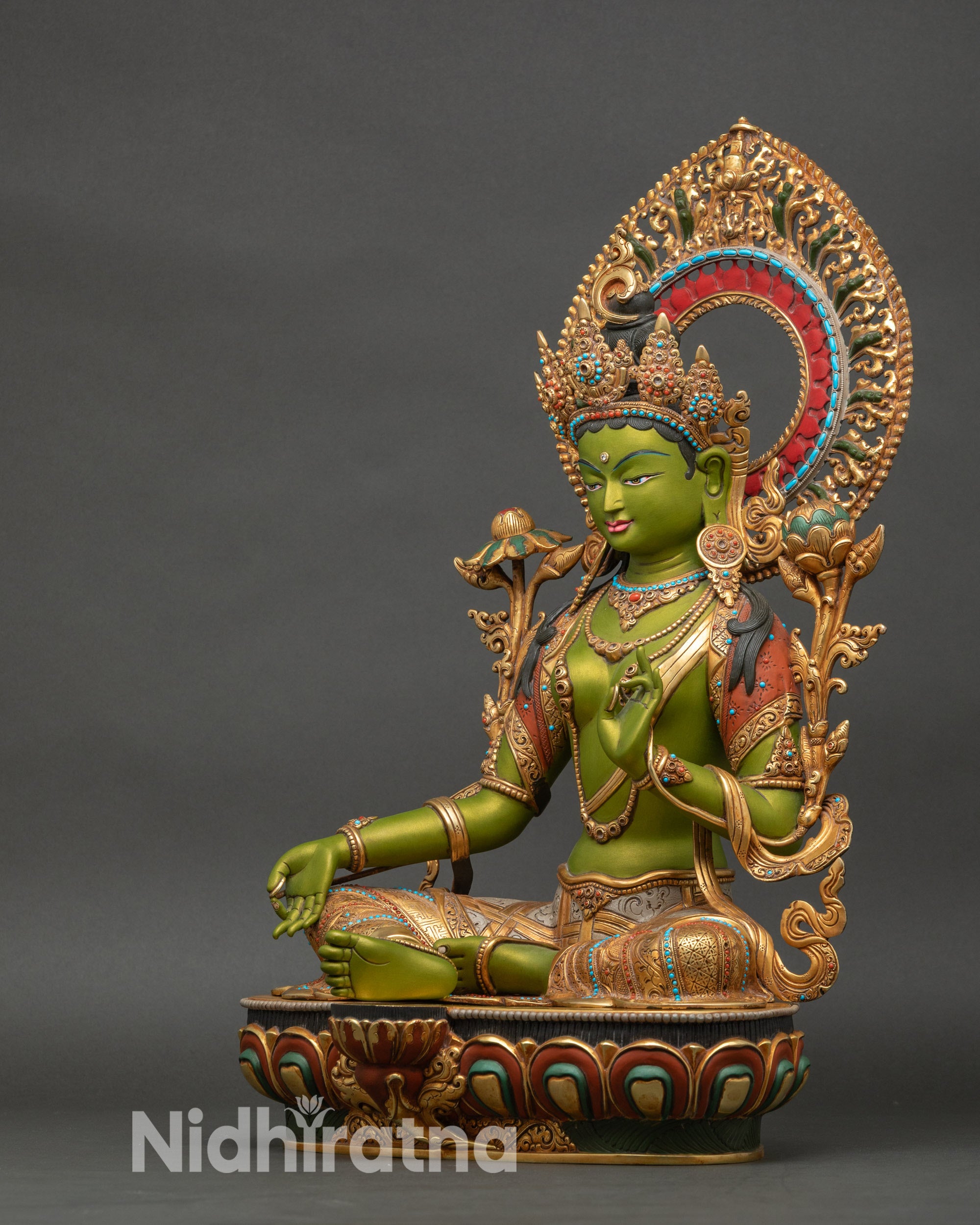 Left profile of Green Tara statue with flowing ornaments and intricate detail