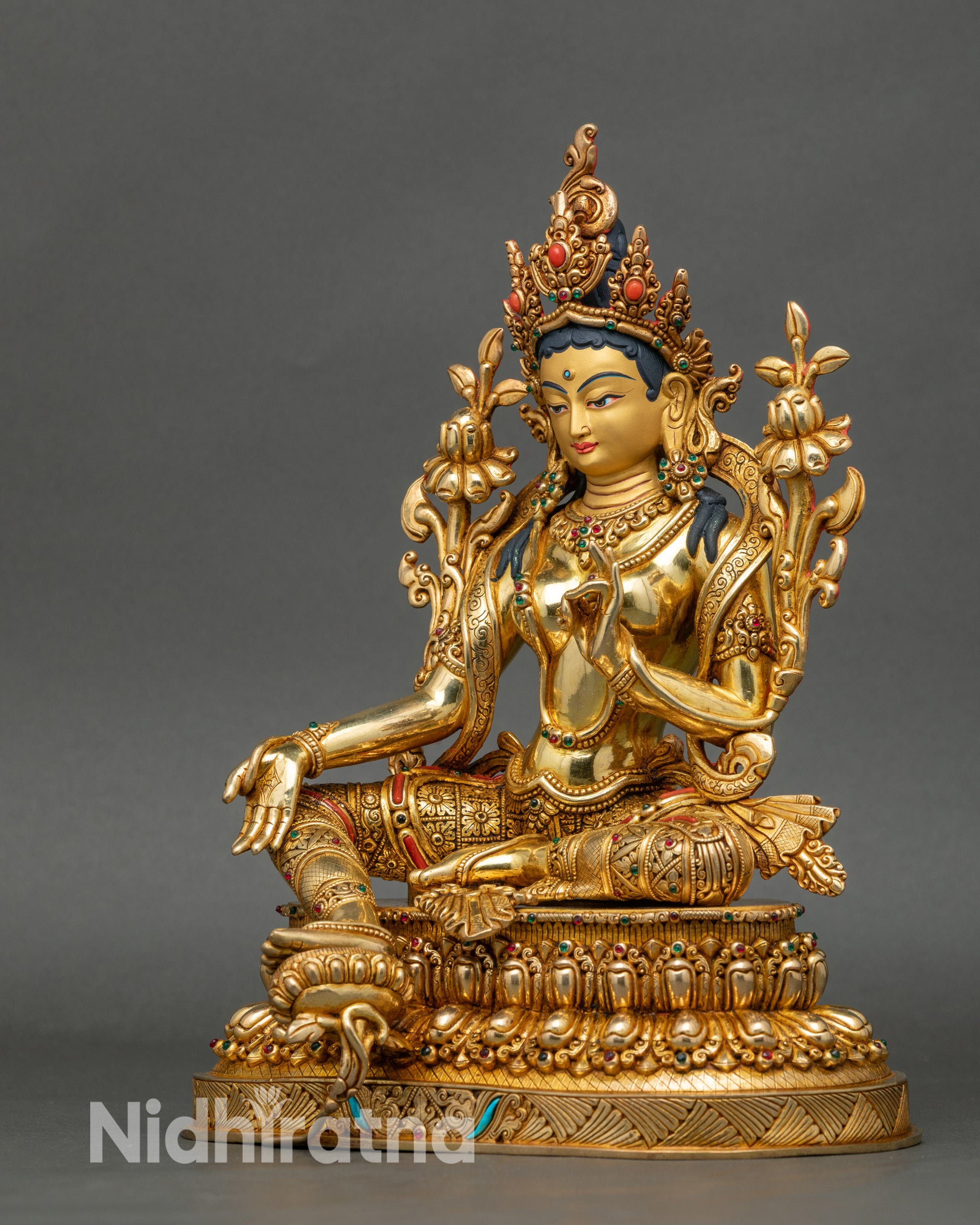 Left profile showing intricate robes and divine halo of Green Tara statue