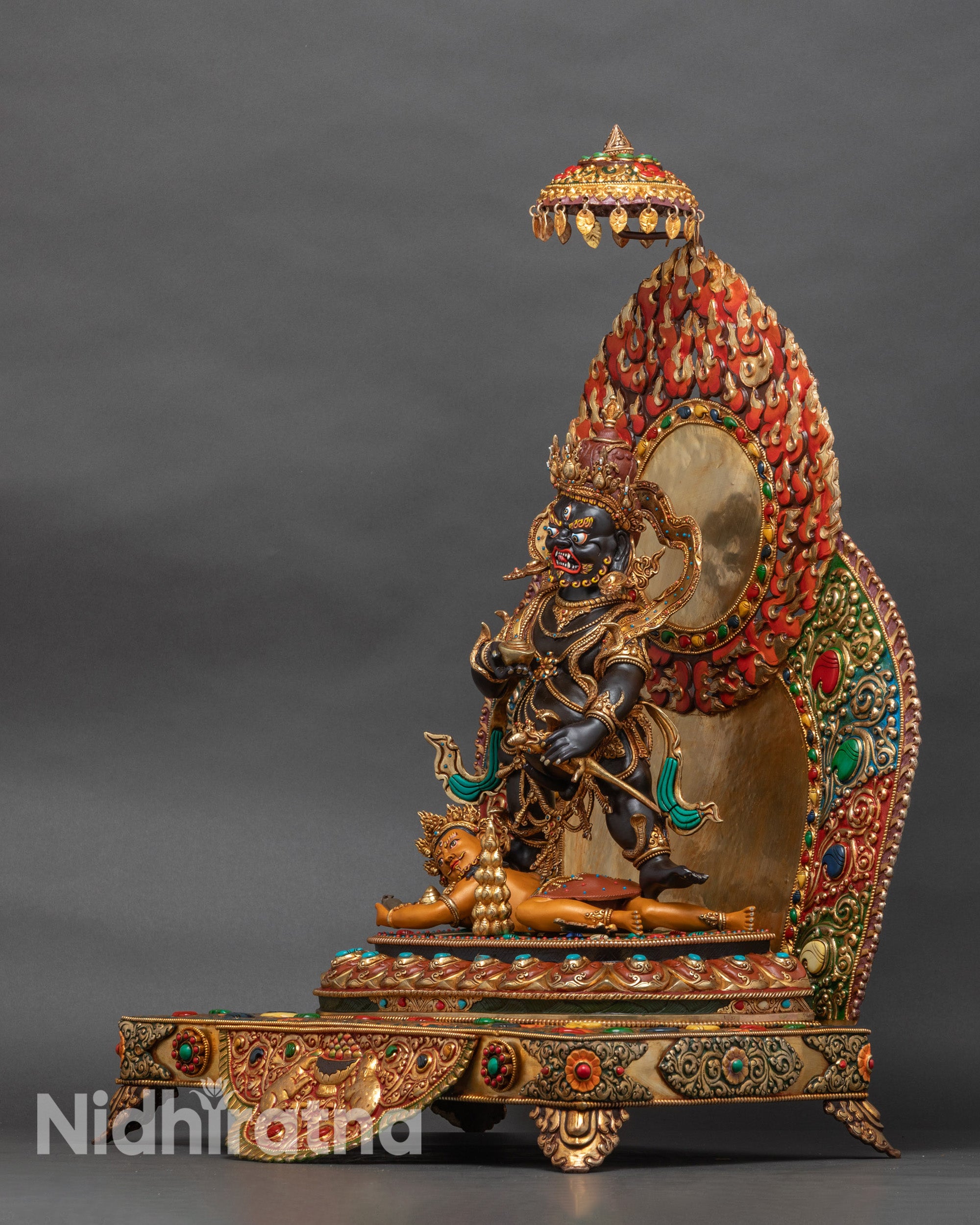 Left side of Black Dzambhala figure highlighting lotus throne and halo