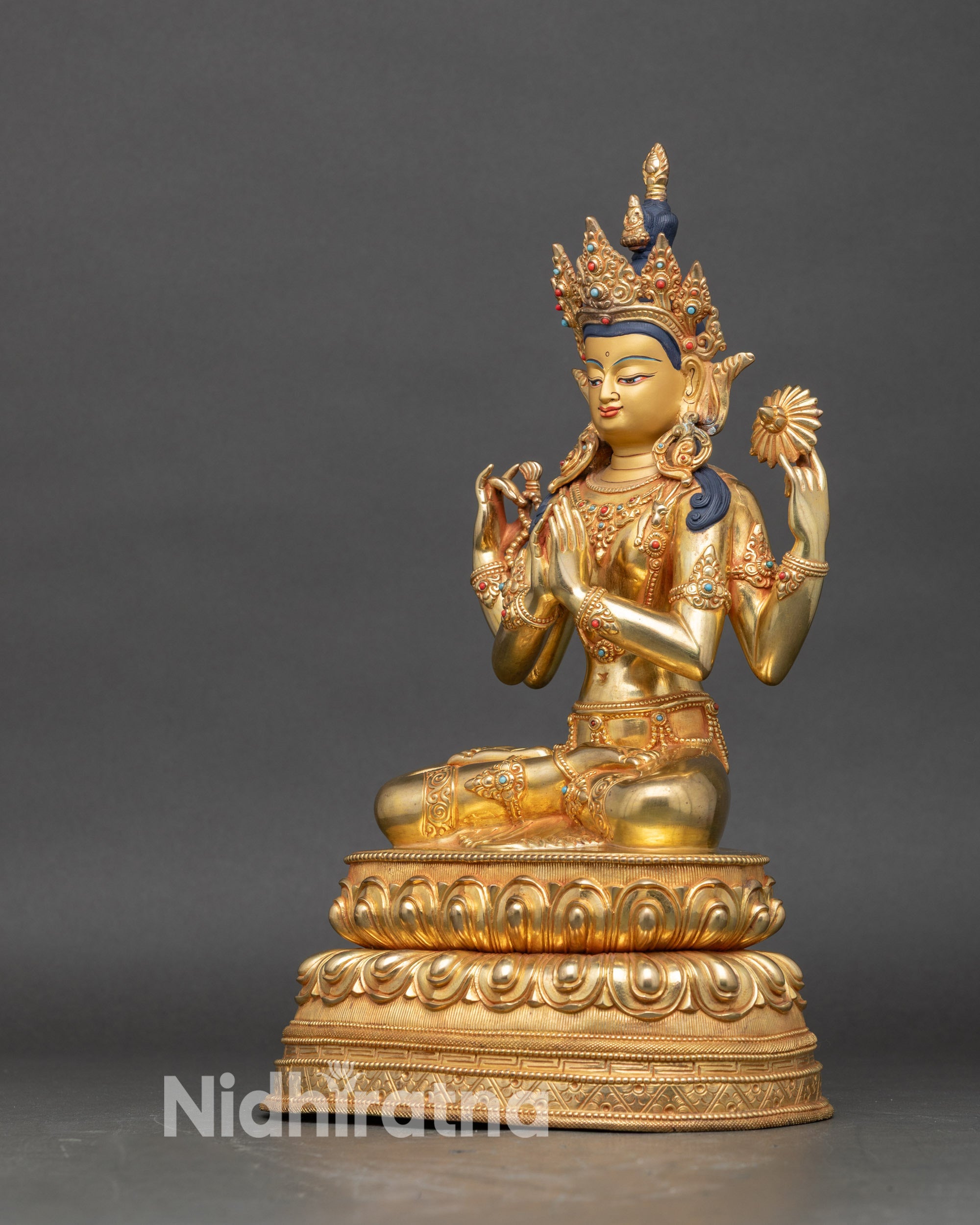 Left side of Chenrezig statue showing lotus flower and gilded robe details