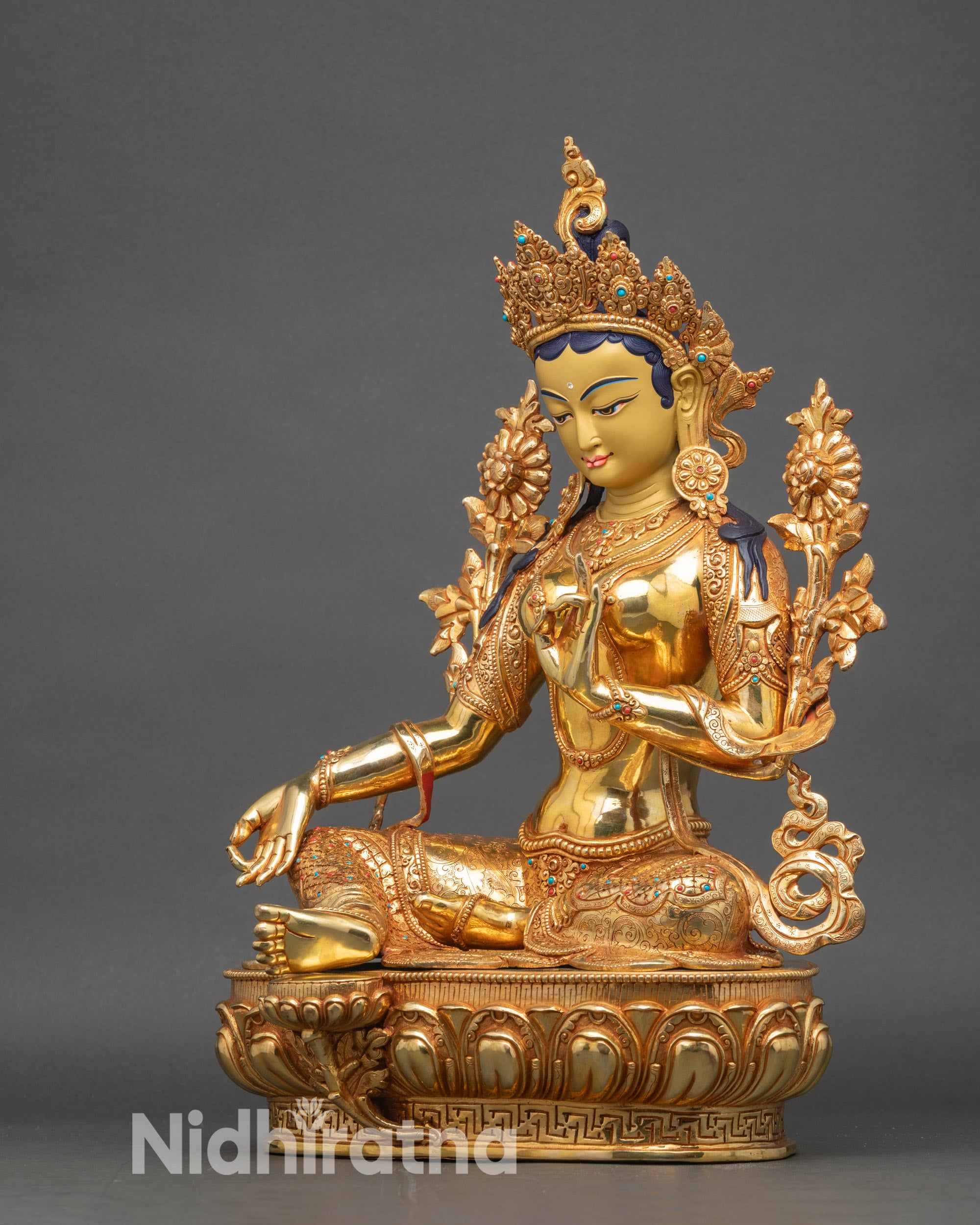 Left side view of Green Tara statue emphasizing copper craftsmanship and gold gilding