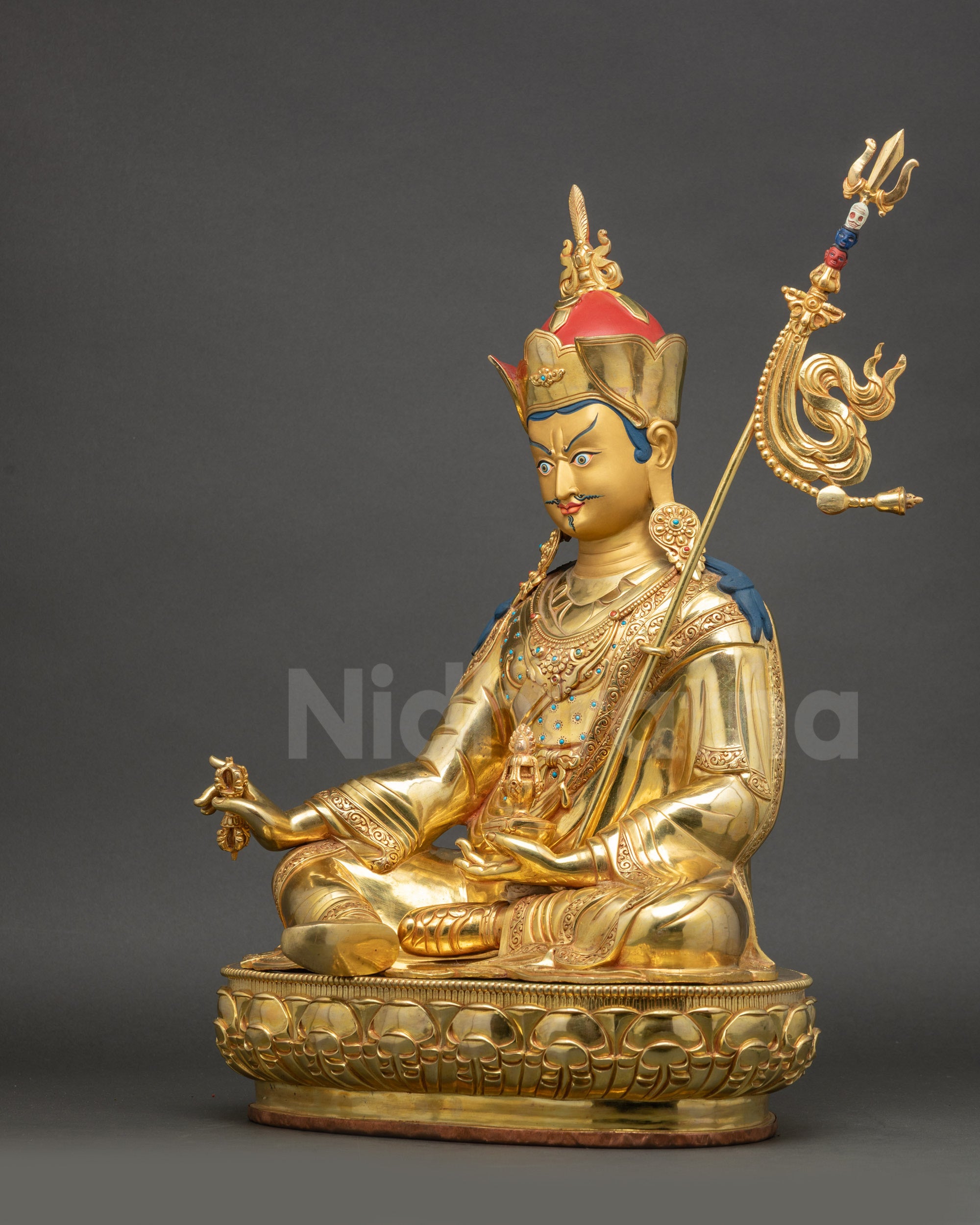 Left side view of Guru Rinpoche Statue with ornate trident and symbolic ornaments visible