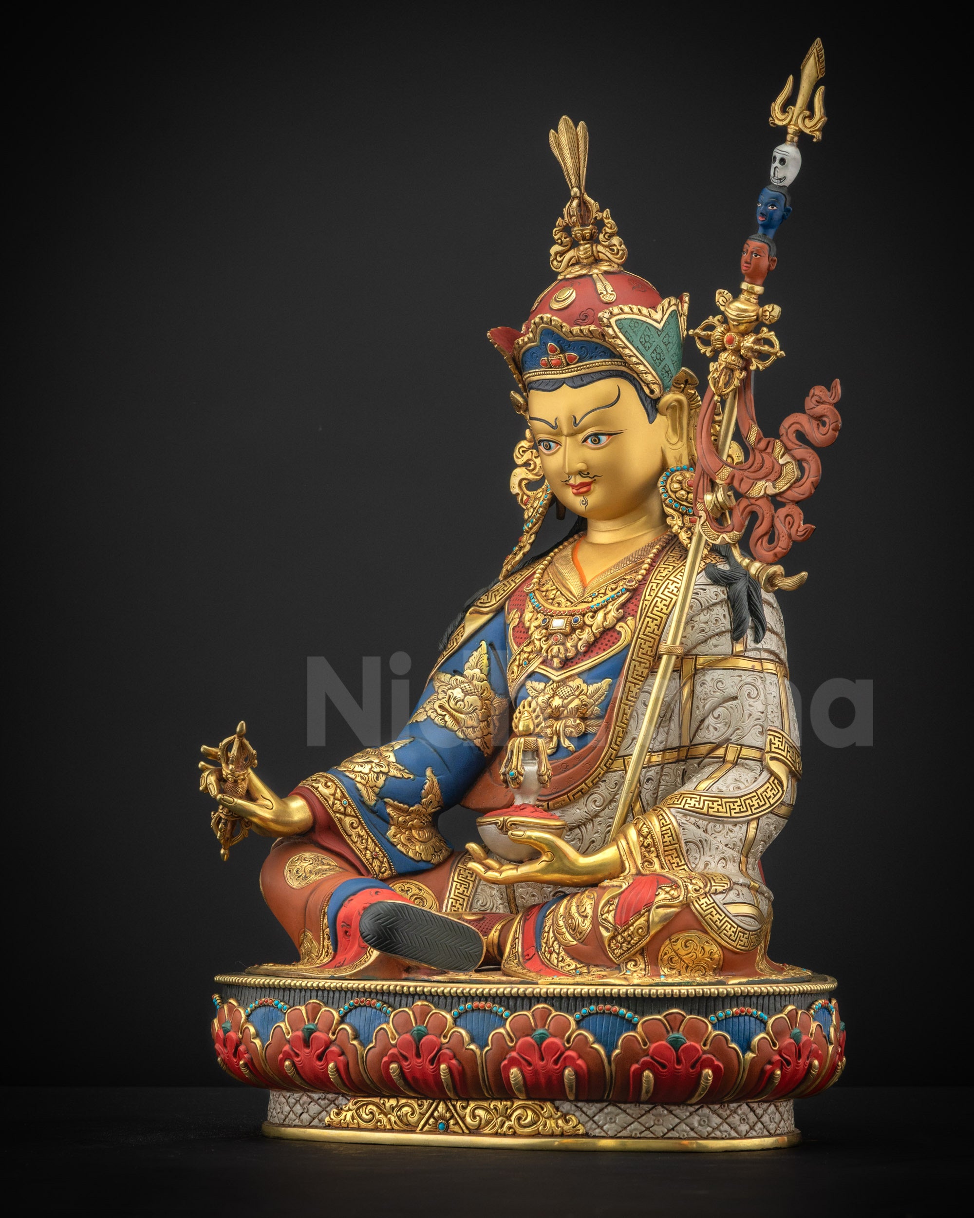Left side view of Guru Rinpoche statue with the khatvanga Trident resting on the shoulder