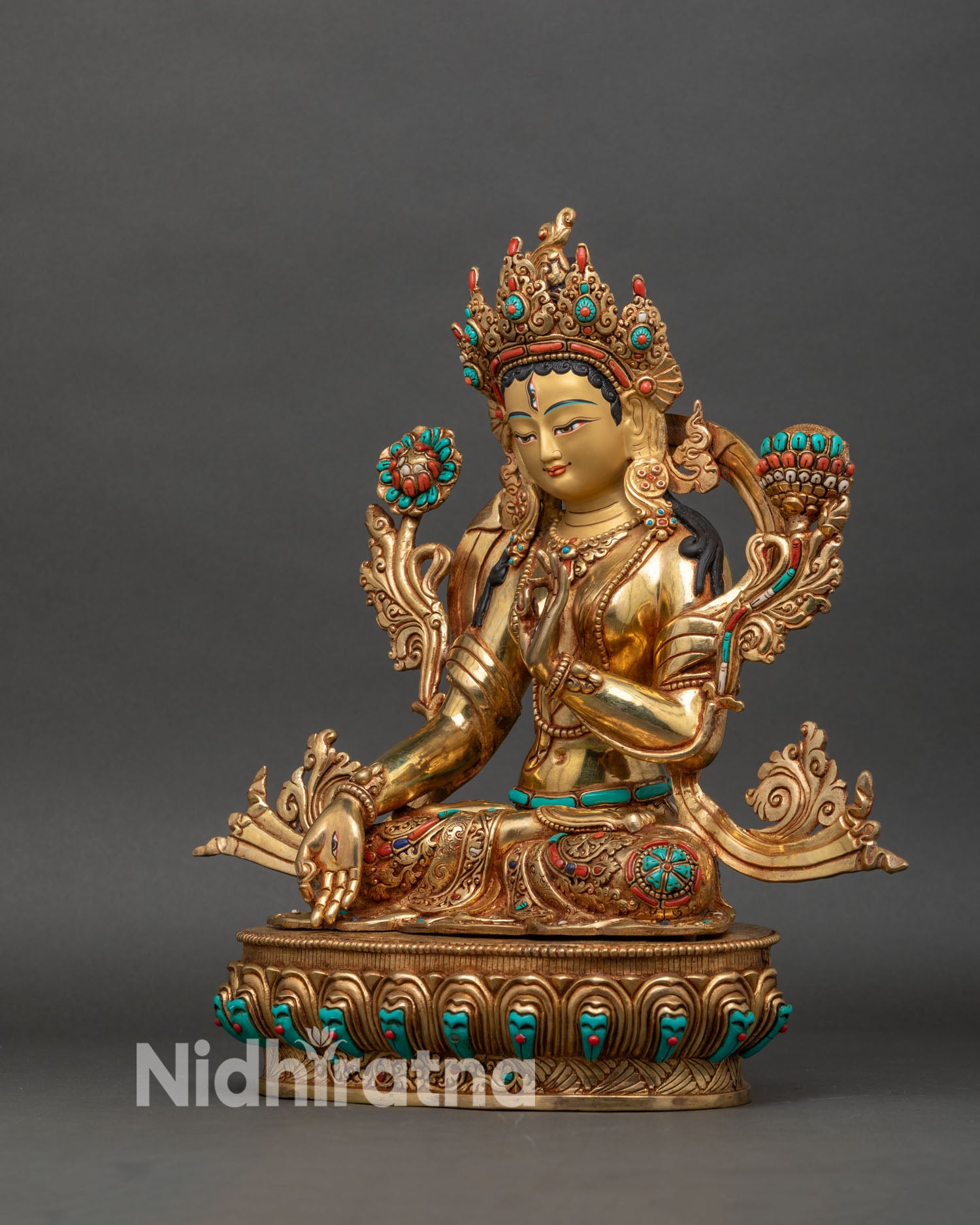 Left side view of White Tara sculpture with layered robes and lotus pedestal