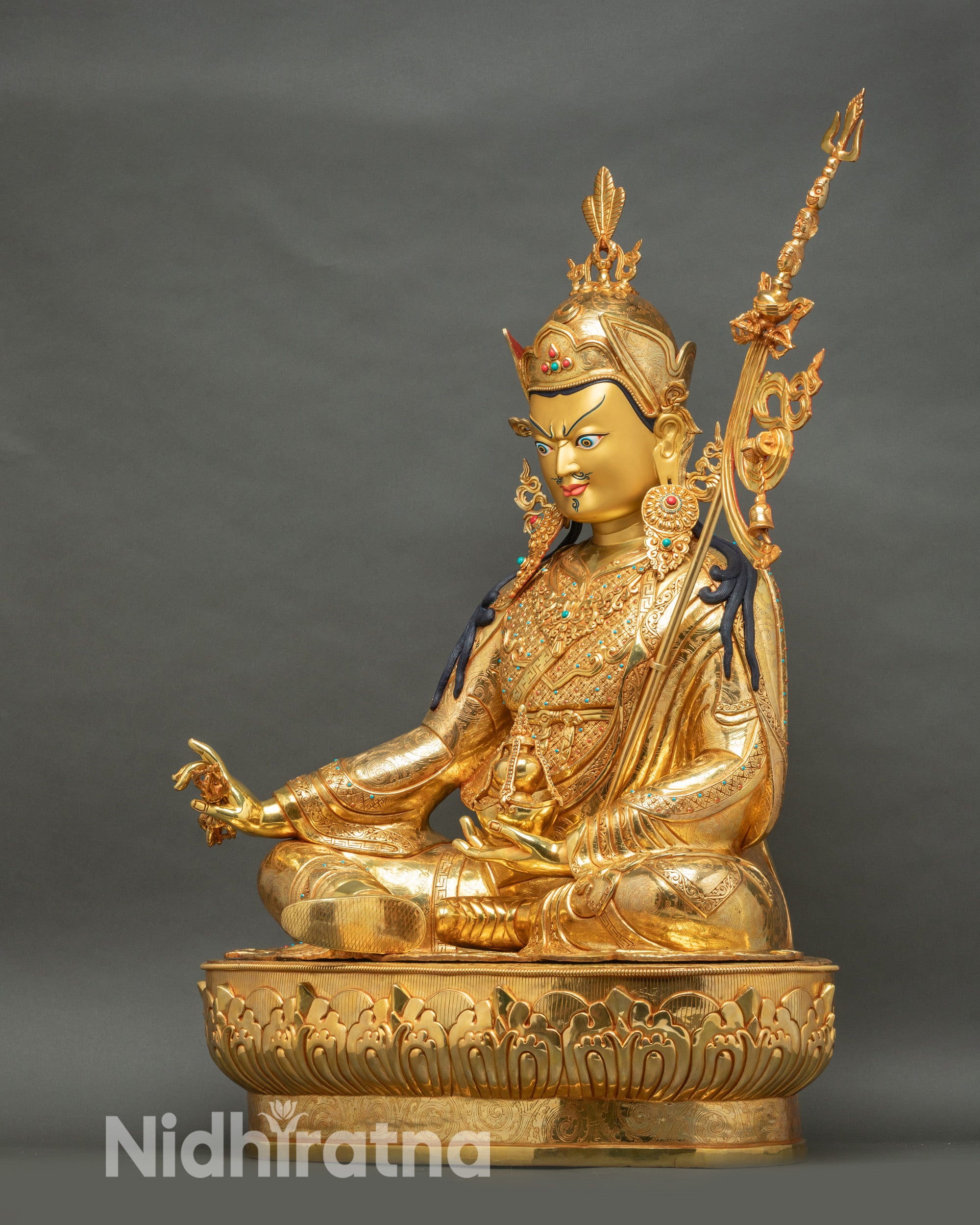Left side view of life-size Padmasambhava statue, vajra and skull cup detail, gold fire-gilded copper, Himalayan Buddhist art