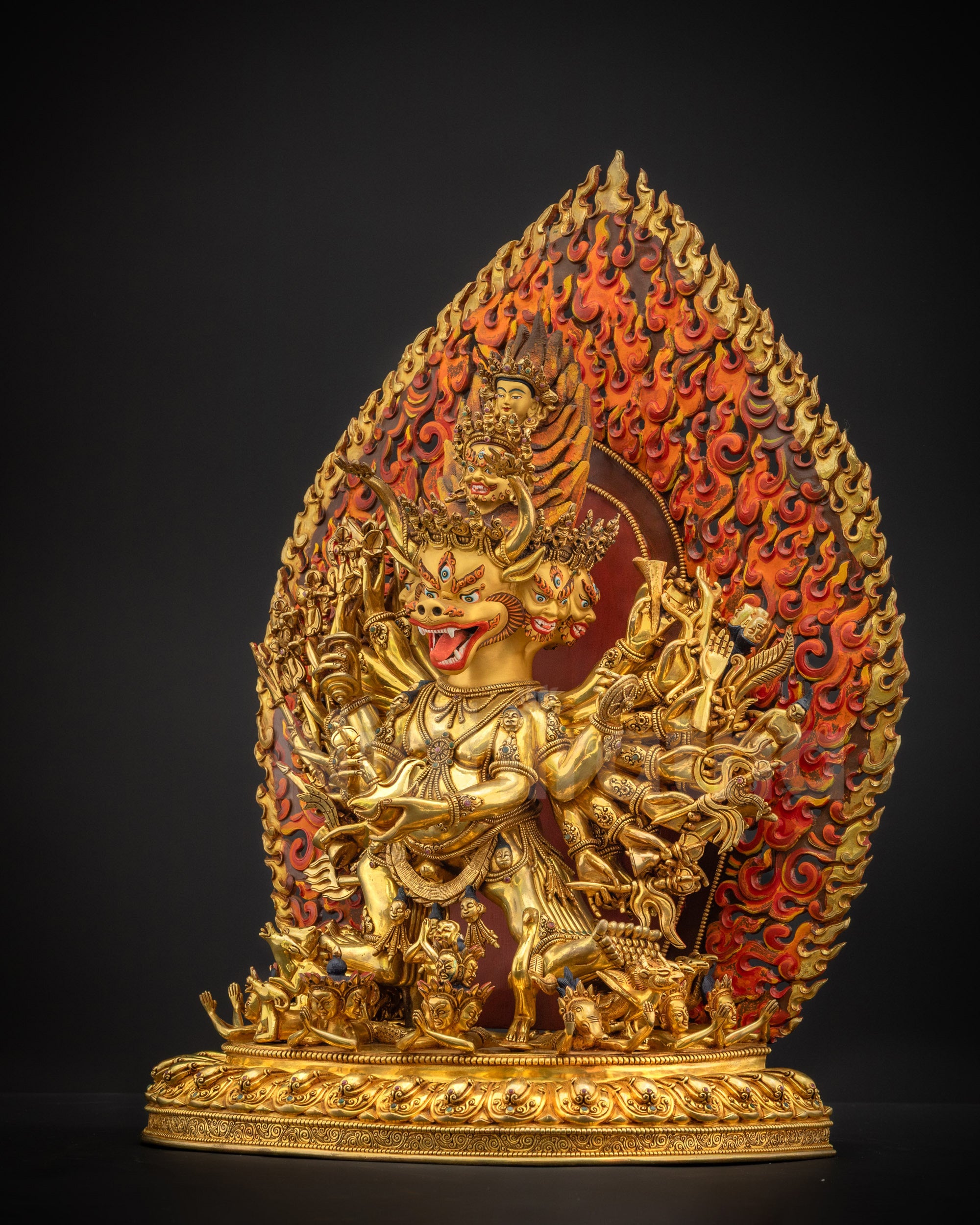 Left side view showing gold fire-gilded 3D carvings, wrathful deity posture, and intricate ritual attributes