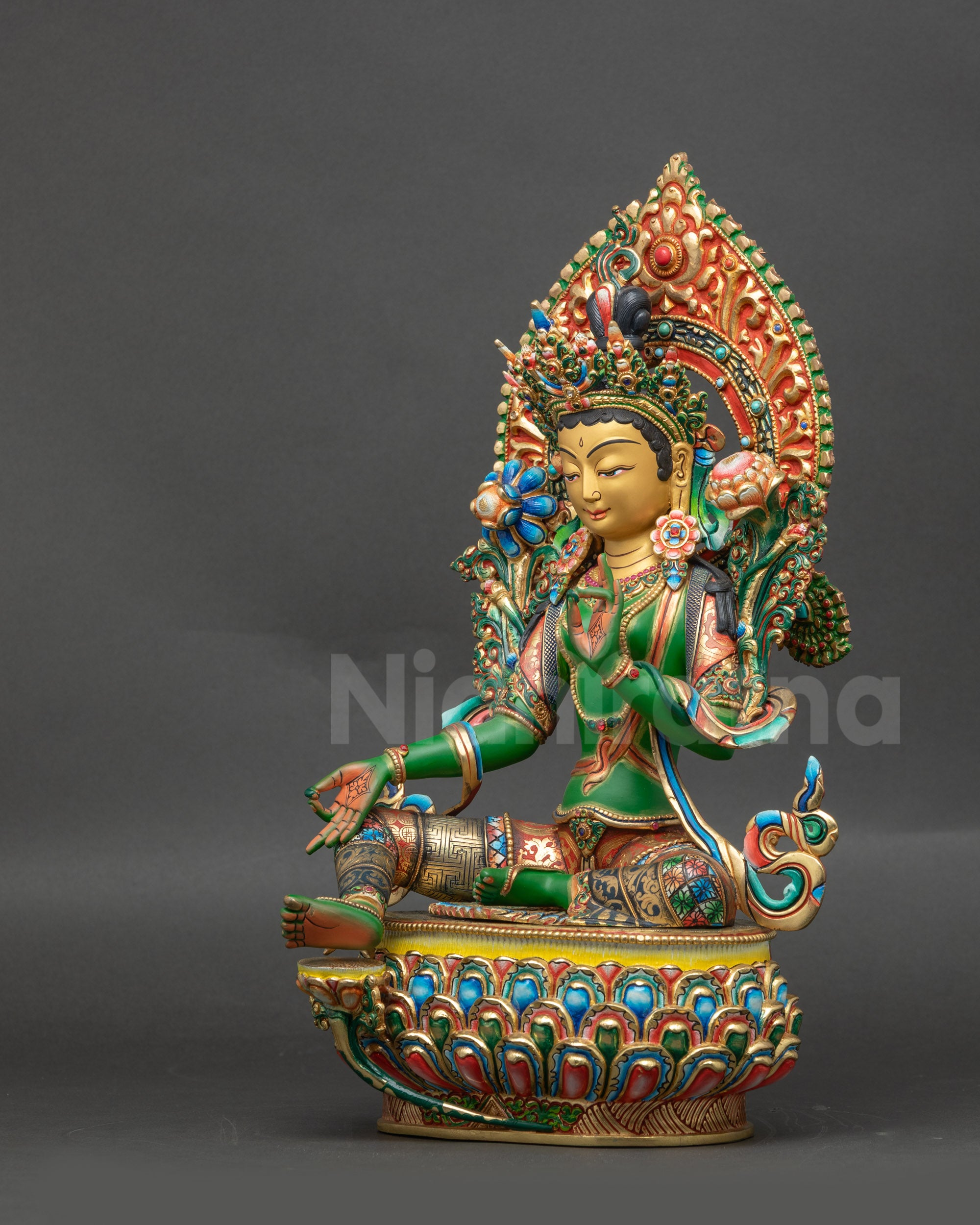Left view side of Green Tara sculpture highlighting flowing robe and lotus-seated posture