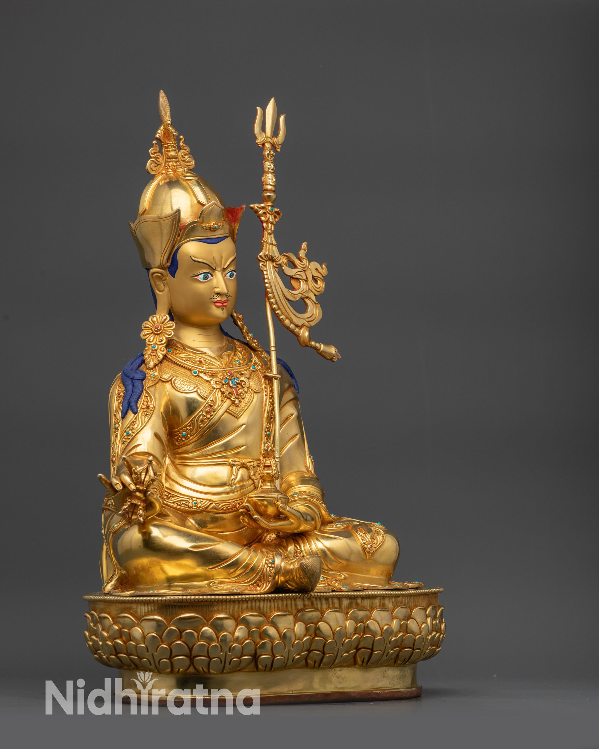 Left view side of Guru Rinpoche statue displaying swirling lotus hat and garments