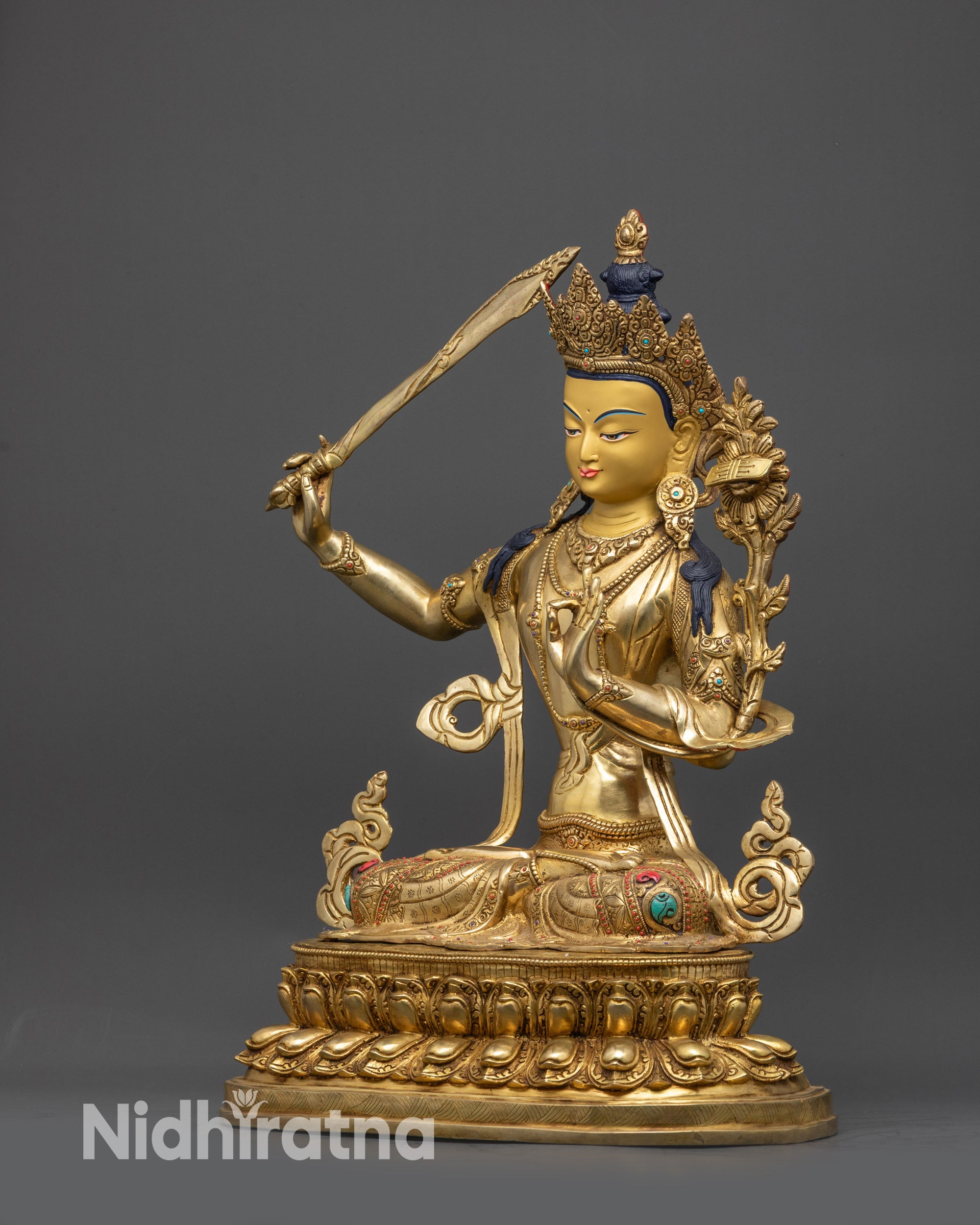 Left view side of Manjushri sculpture highlighting gold-gilded robes and sacred symbols