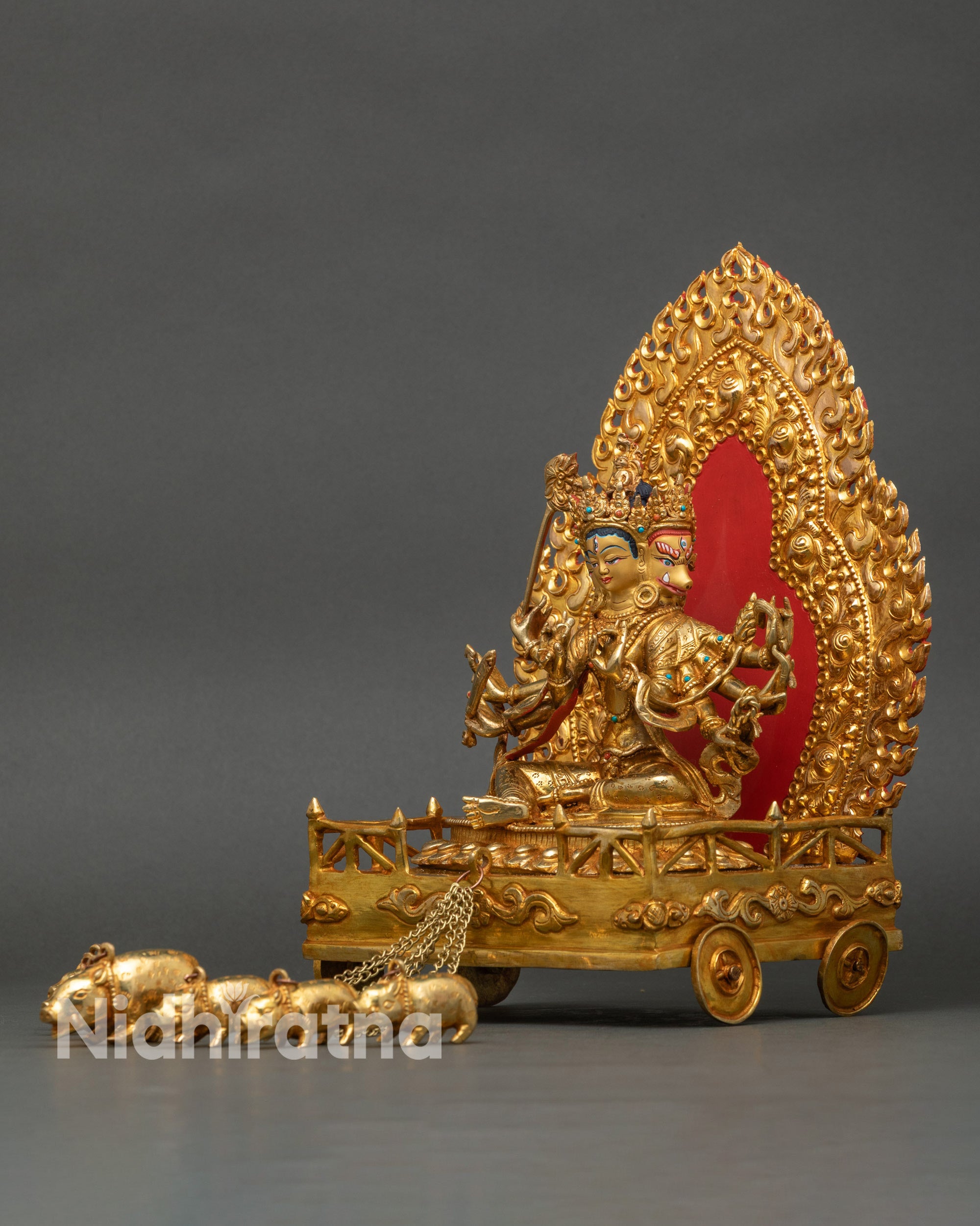 Left view side of golden Marichi statue showing detailed arms and sacred symbols