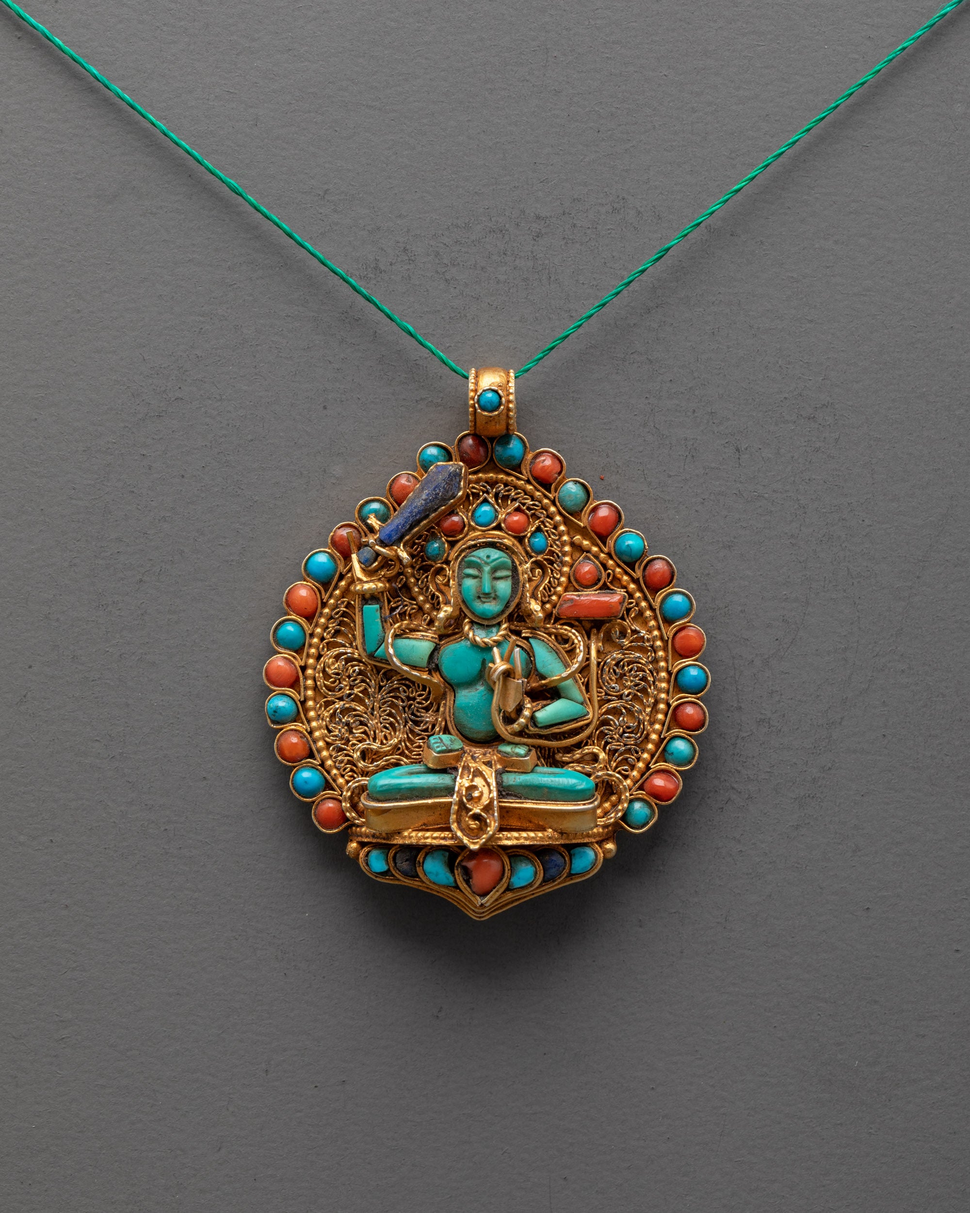 Front angle of Manjushri Locket with turquoise figure and gold-gilded Himalayan filigree design