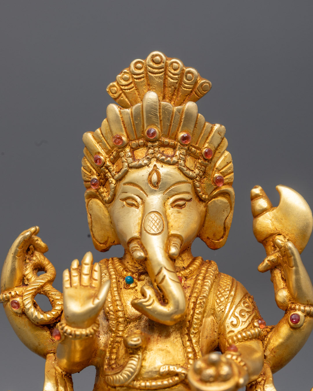 Lord Ganesha’s gold-gilded face and Varada Mudra hand blessing devotees – detailed Hindu elephant god ido
