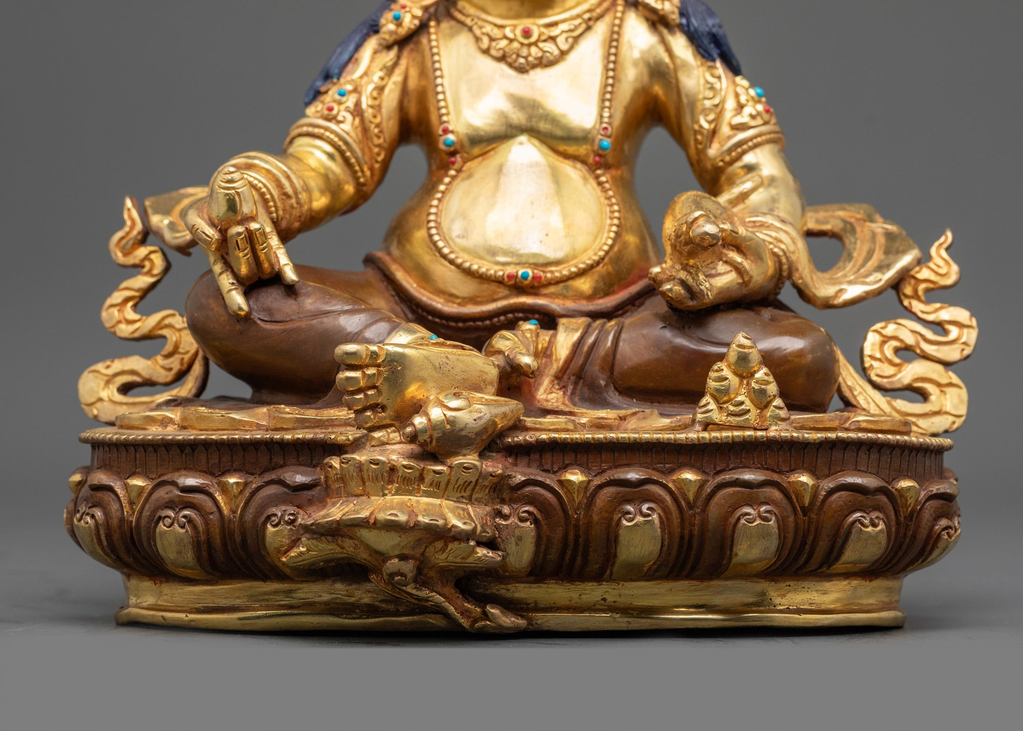 Low view of Dzambhala Statue highlighting intricate gold gilding and detailed craftsmanship