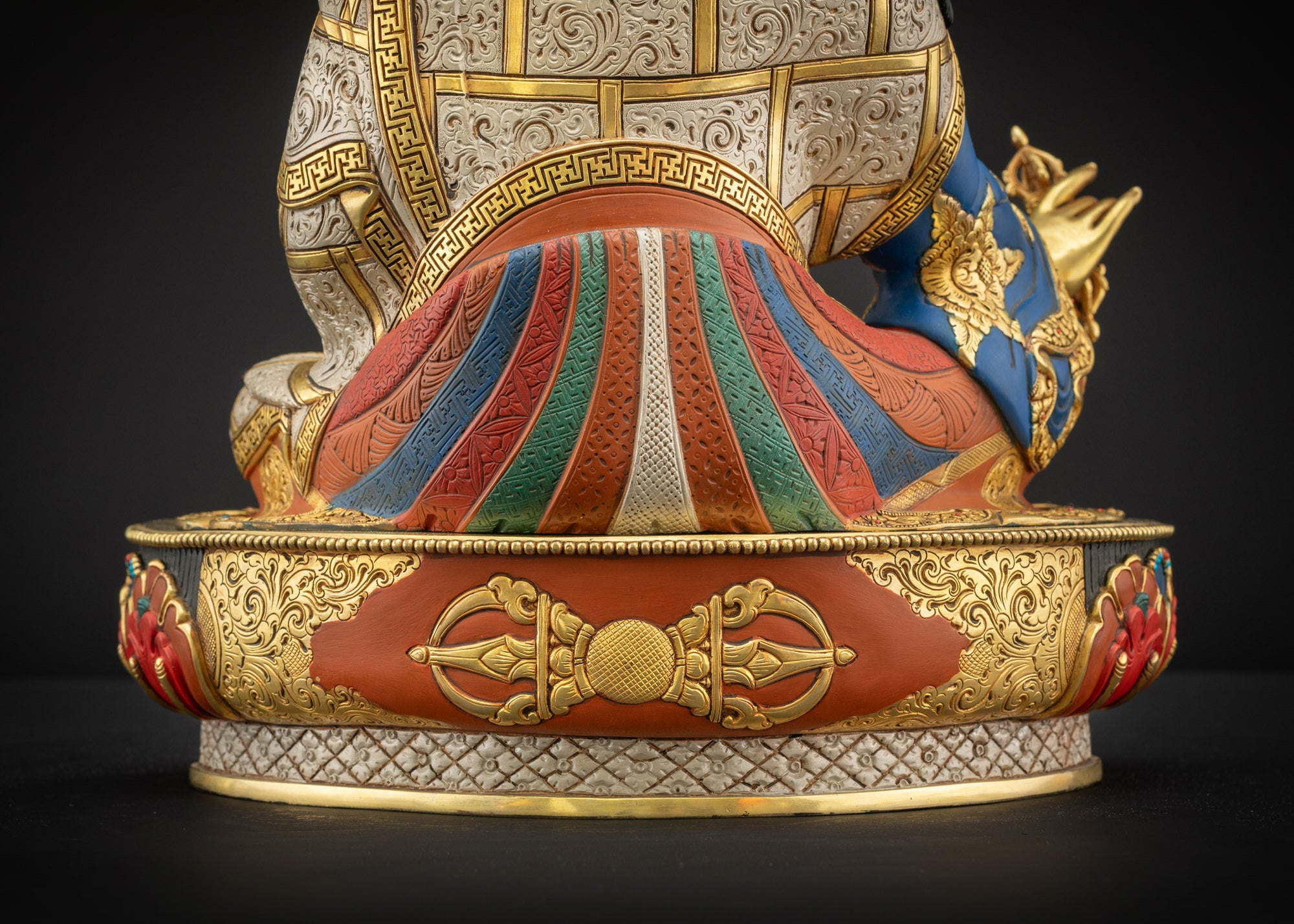 Lower back view of Guru Rinpoche statue showing pedestal and robe folds