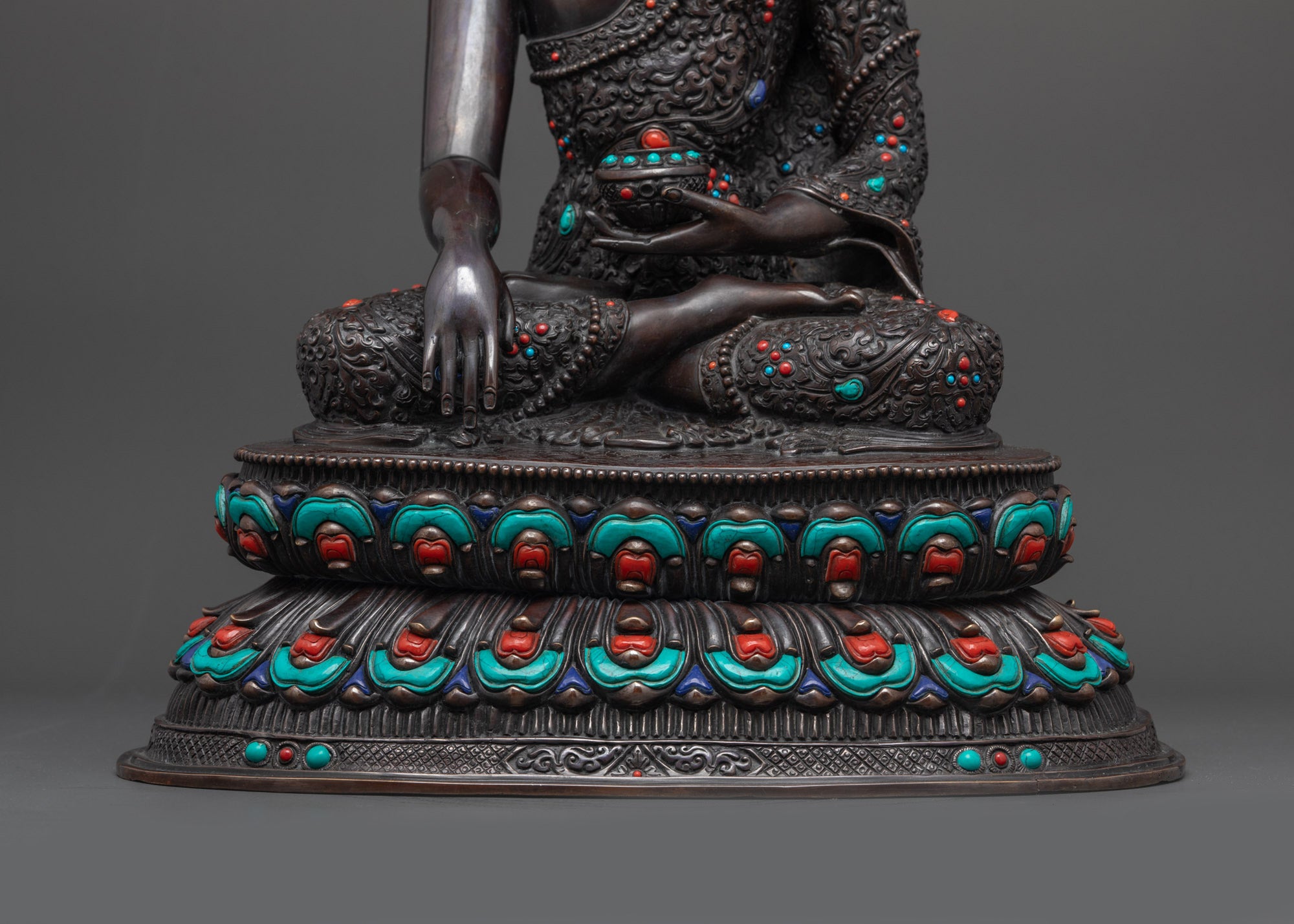 Lower landscape shot of statue seated on lotus seat front Buddha Shakyamuni oxidized