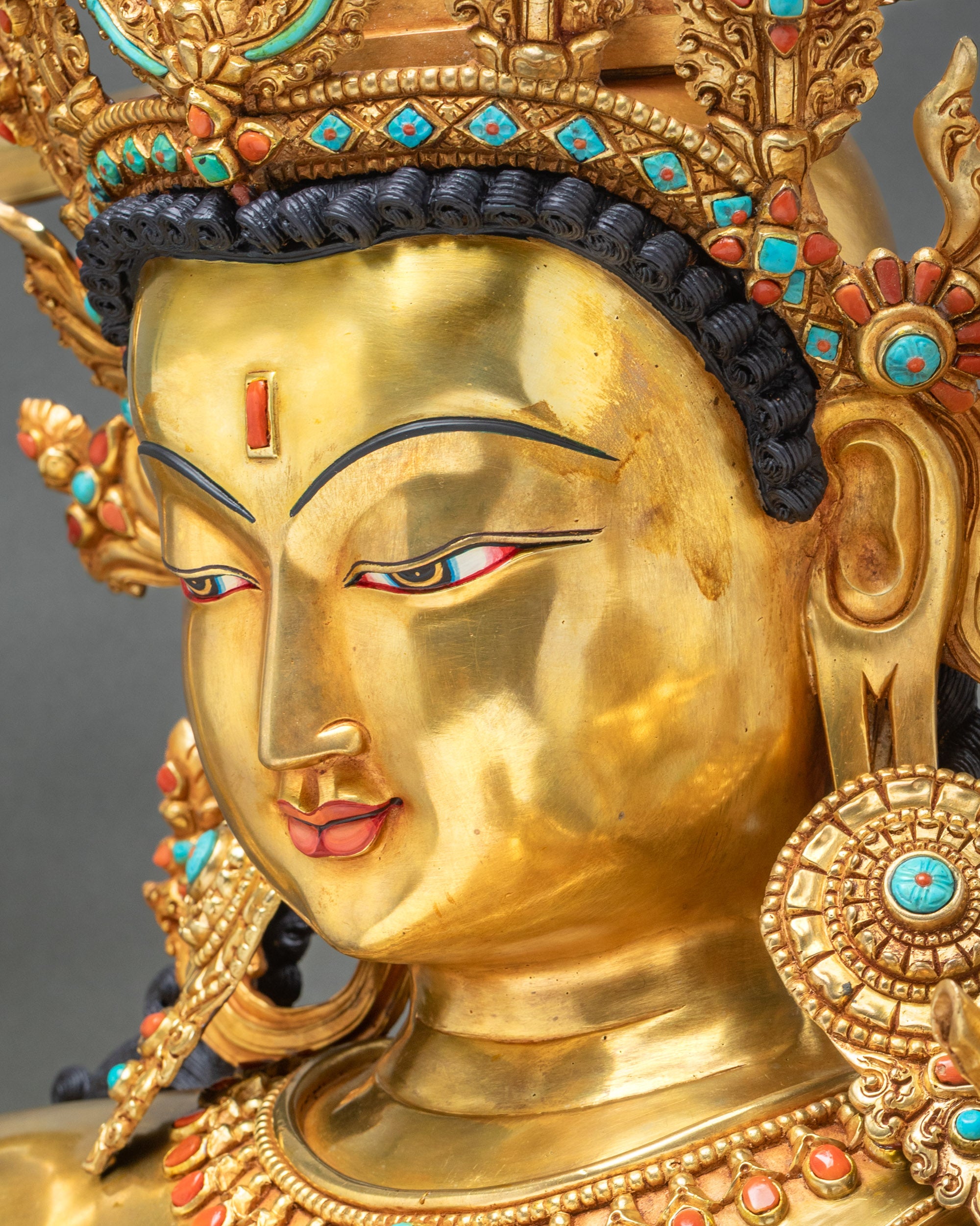 Maha Manjushri statue face profile with jeweled crown, ornate headdress, peaceful expression, and handcrafted gold fire-gilded features