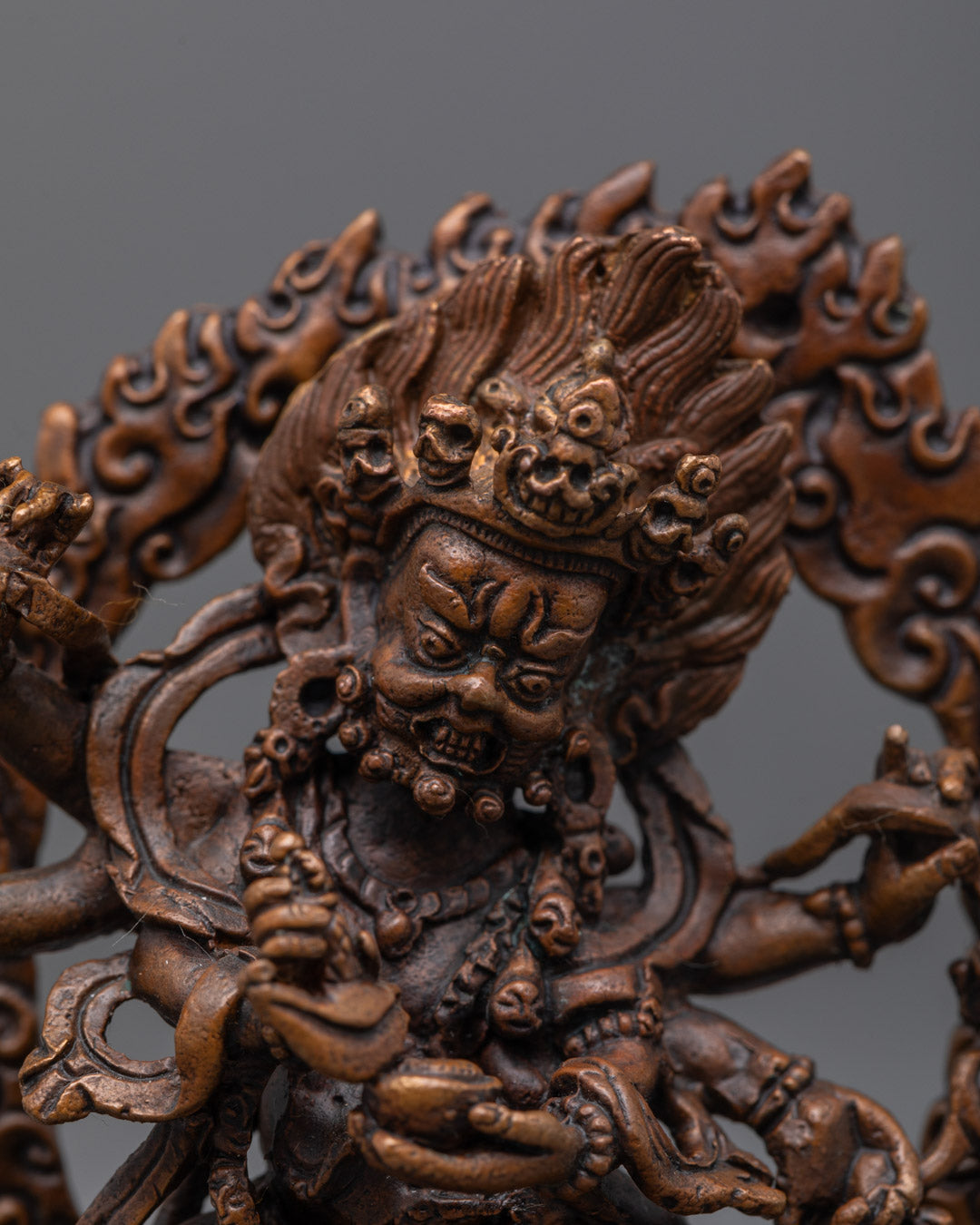 Mahakala’s face showing wrathful expression, five-skull crown, and detailed acrylic painting