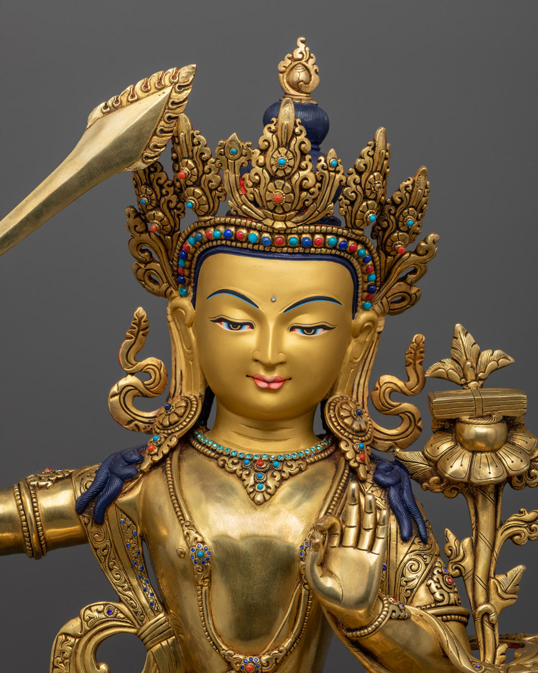 Manjushri statue in copper alloy with pure gold gilding, holding symbolic sword and scripture on lotus stem