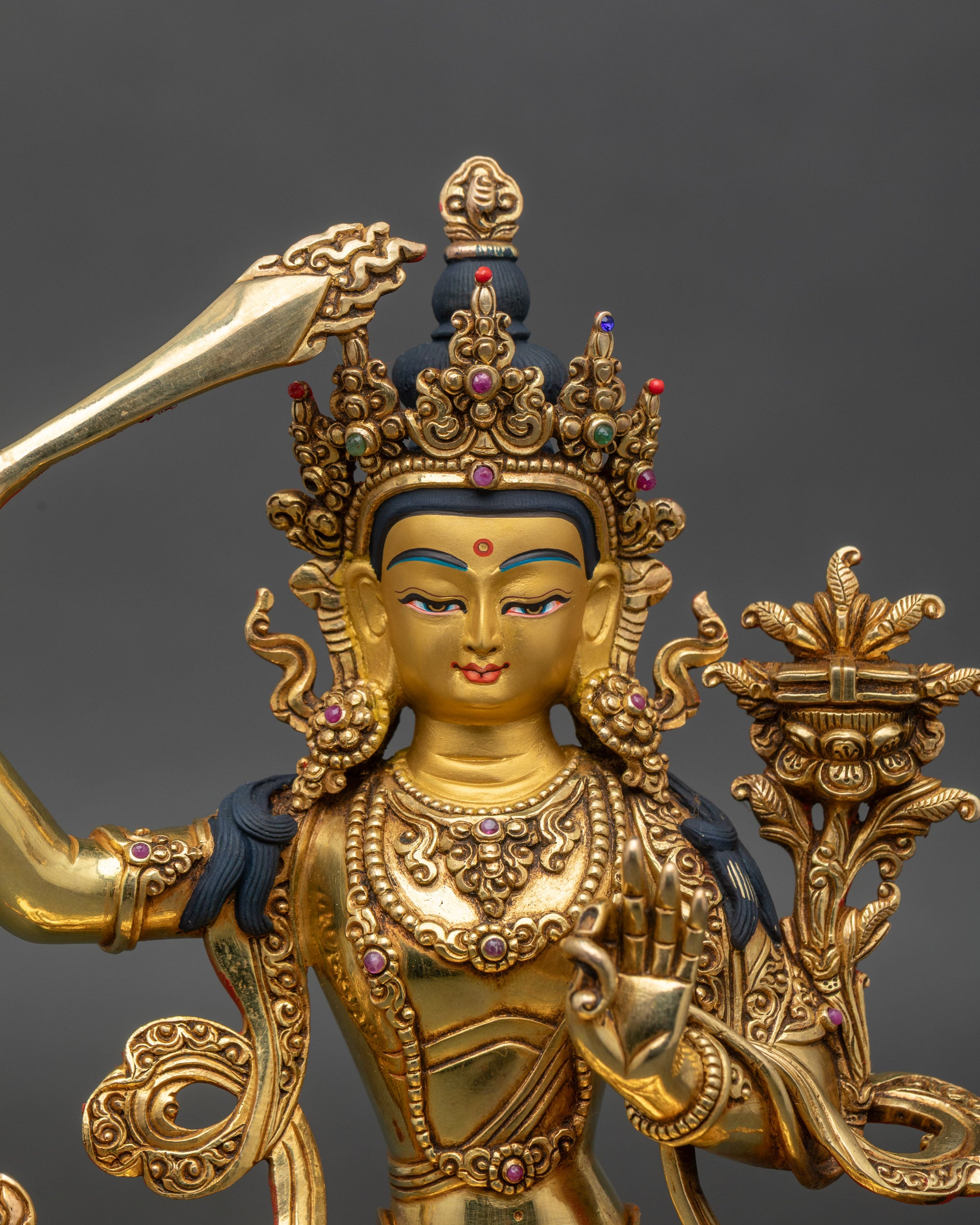 Manjushri Buddha close-up, serene expression, gold fire-gilded spiritual figurine