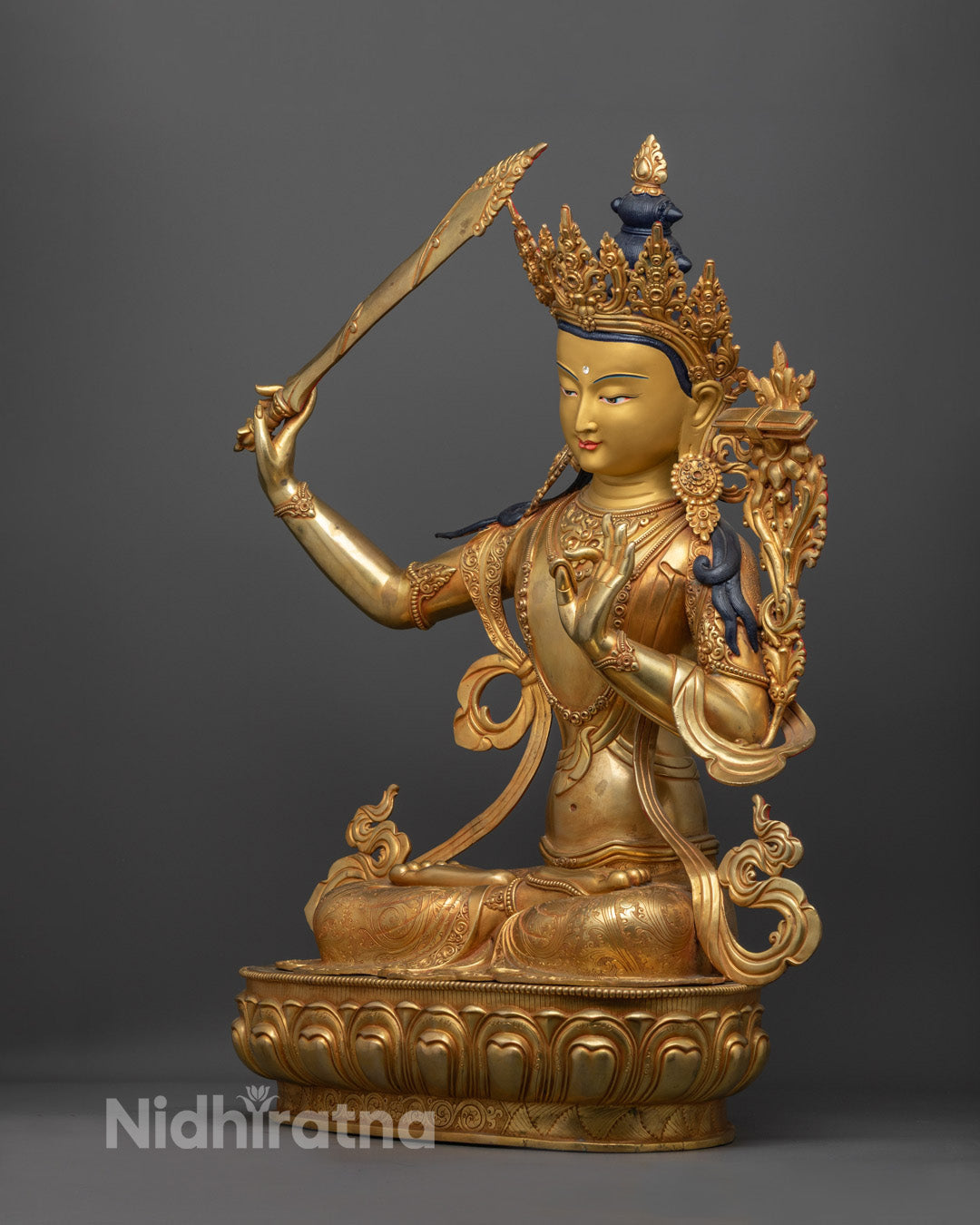 Manjushri’s flowing robe, finely carved ornaments, and rich acrylic coloring with semi-precious embellishments.