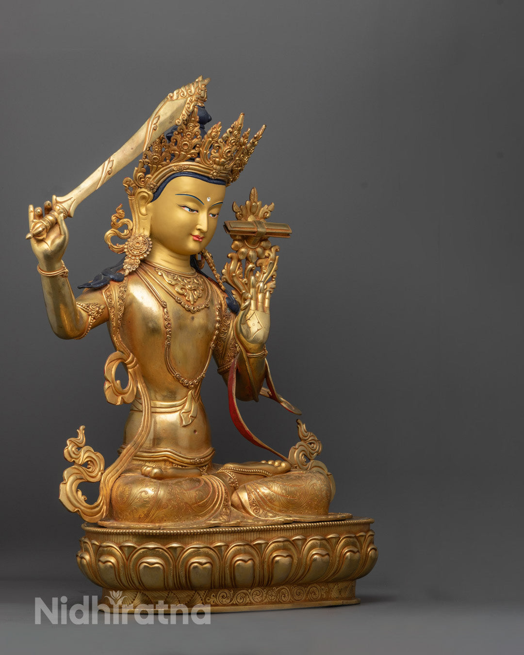 Manjushri sculpture showing the Utpala flower holding the Perfection of Wisdom Sutra in his right hand.