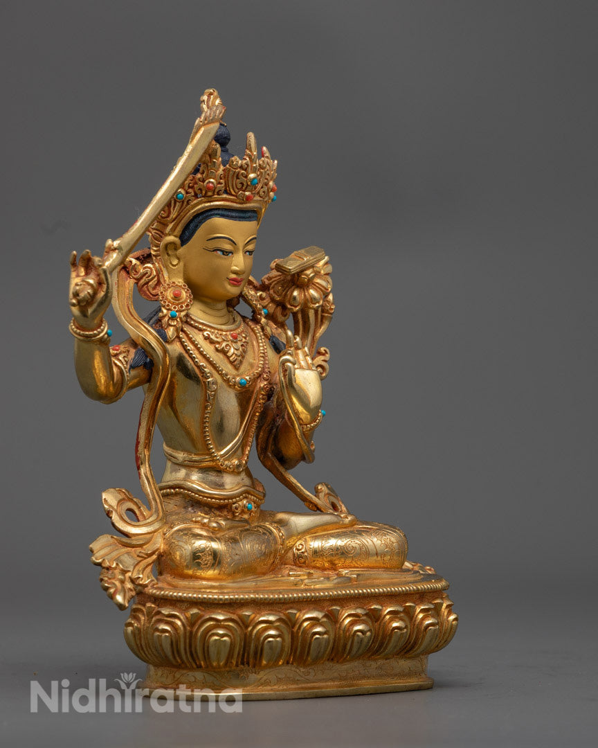 Manjushri statue revealing intricate detailing on crown, robe, and the book of transcendent wisdom on a lotus pedestal.