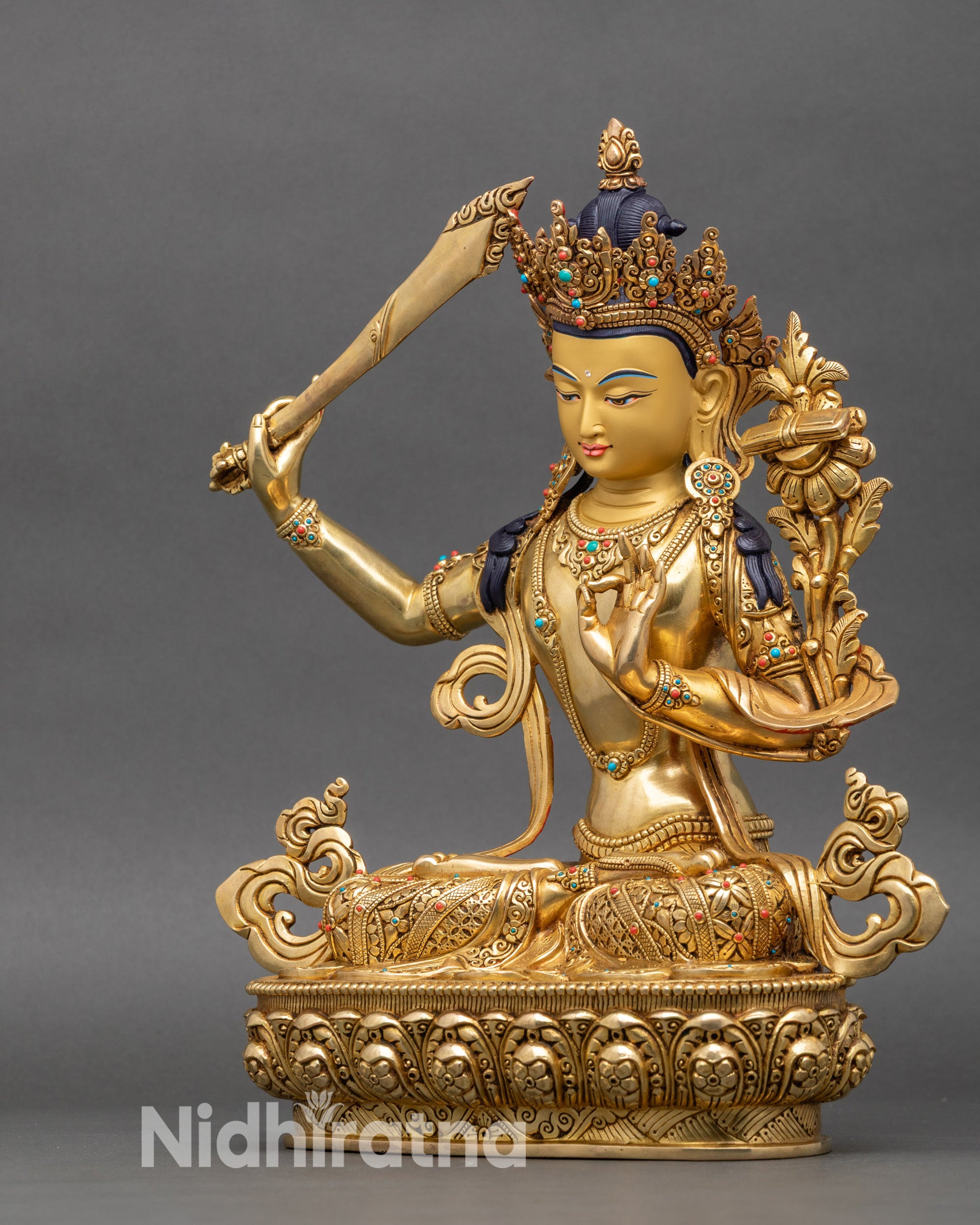 Manjushri statue right profile holding wisdom sword, gold fire-gilded copper with carved details