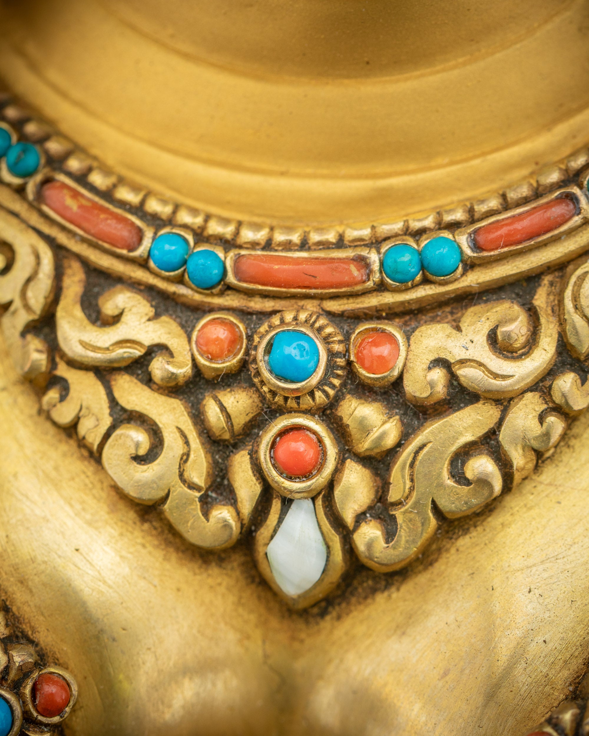 Necklaces close up Green Tara Statue adorned with jewels and gold gilding