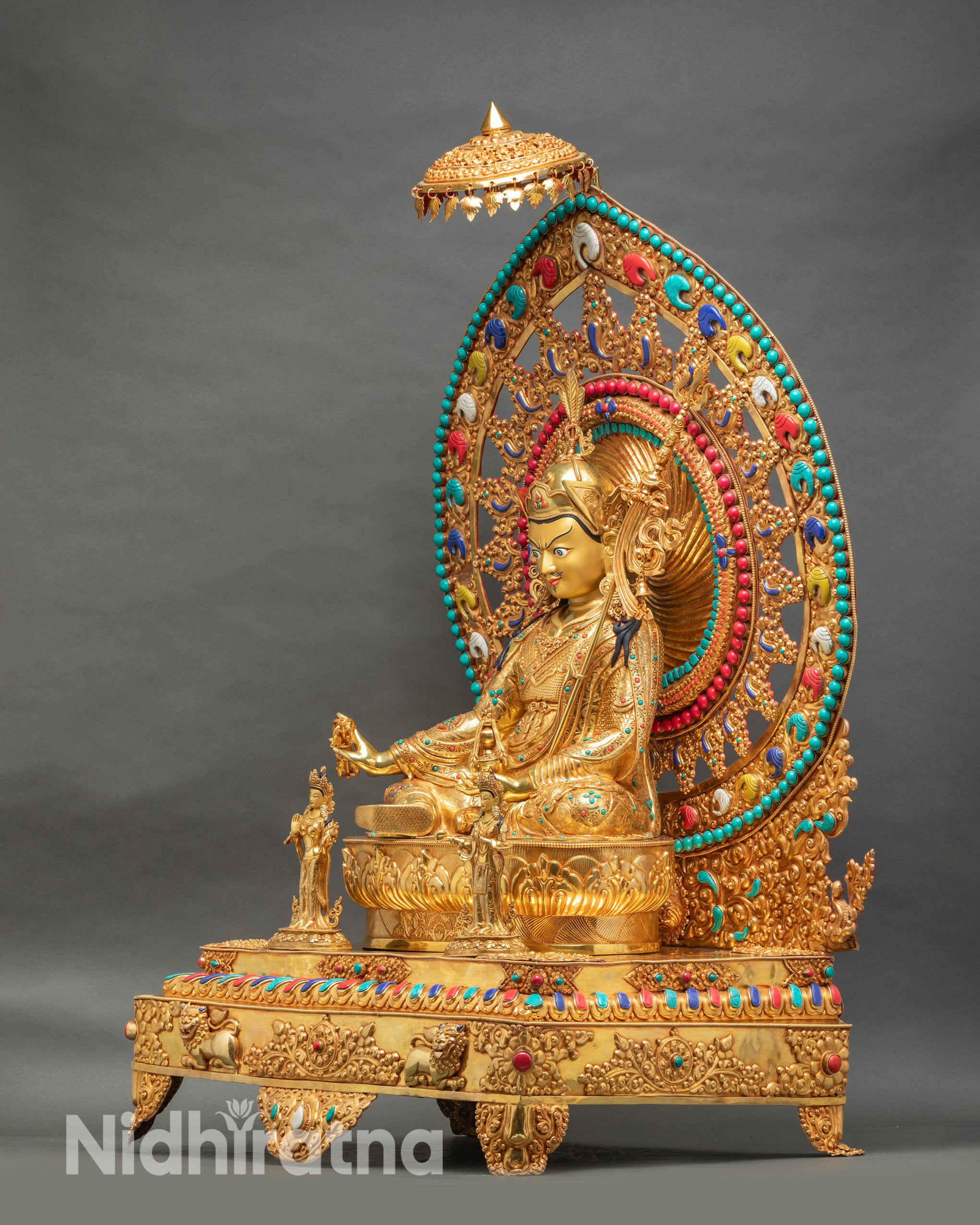 Padmasambhava statue from left angle revealing hand-gilded throne with filigree scrollwork and decorative details