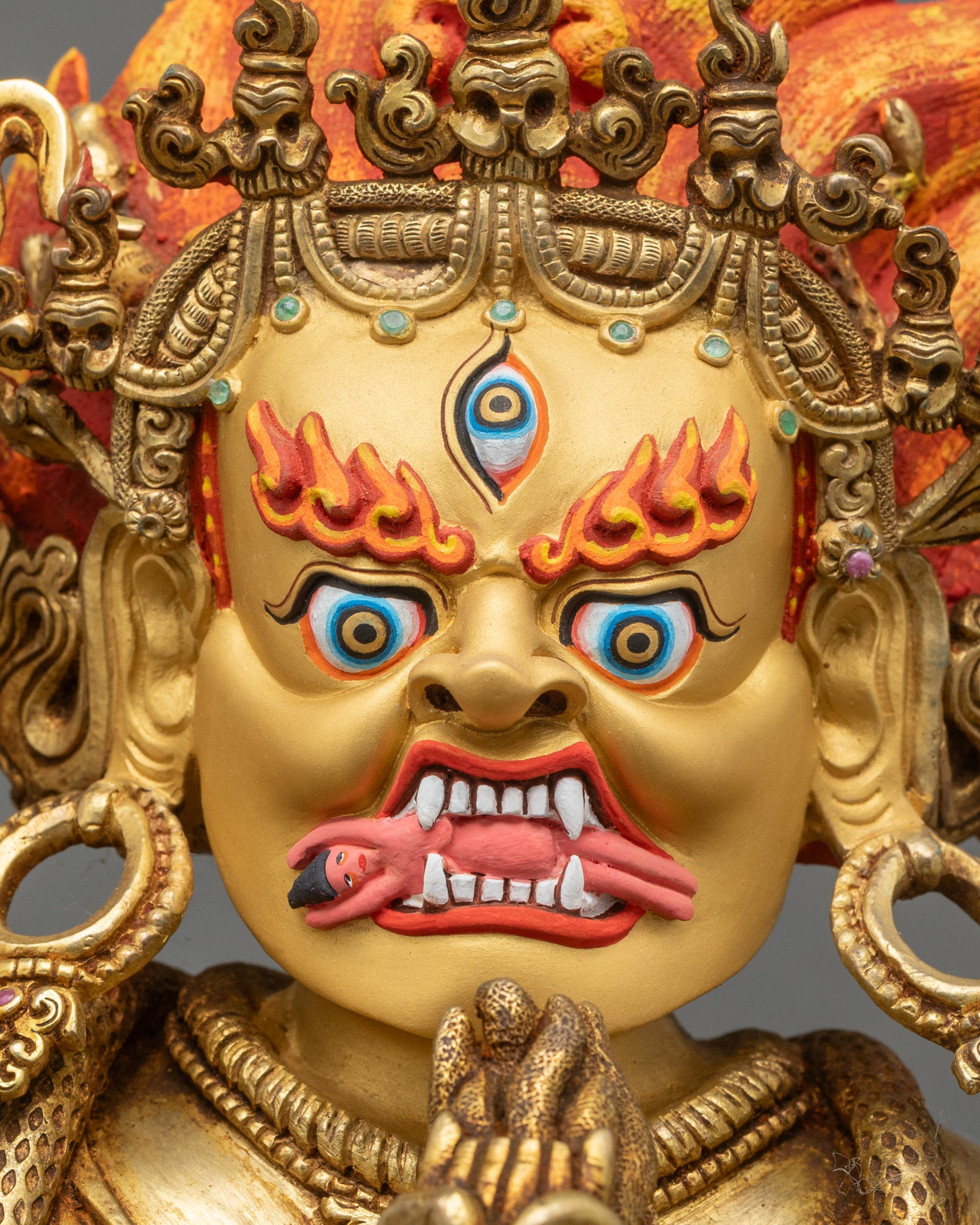 Palden Lhamo wrathful face, three eyes, bared teeth, flaming red hair, five-skull crown, gold painted