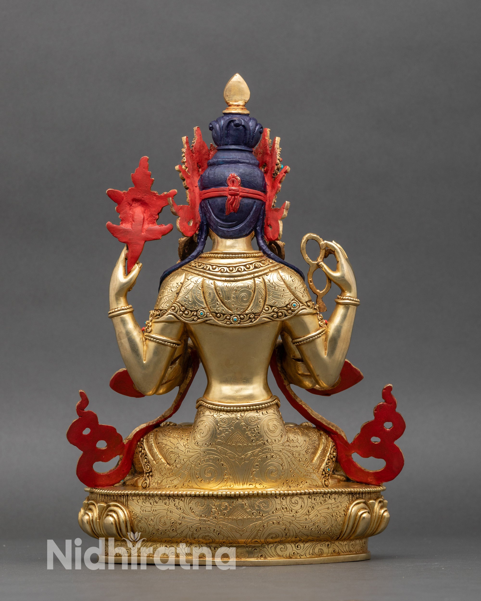 Rear view of gold fire-gilded Avalokiteshvara statue showing carved robes and lotus base